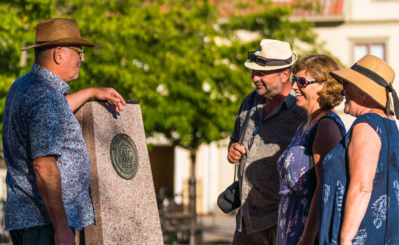 Människor som tittar på Europa Nostra plakett på torget i Hjo. 