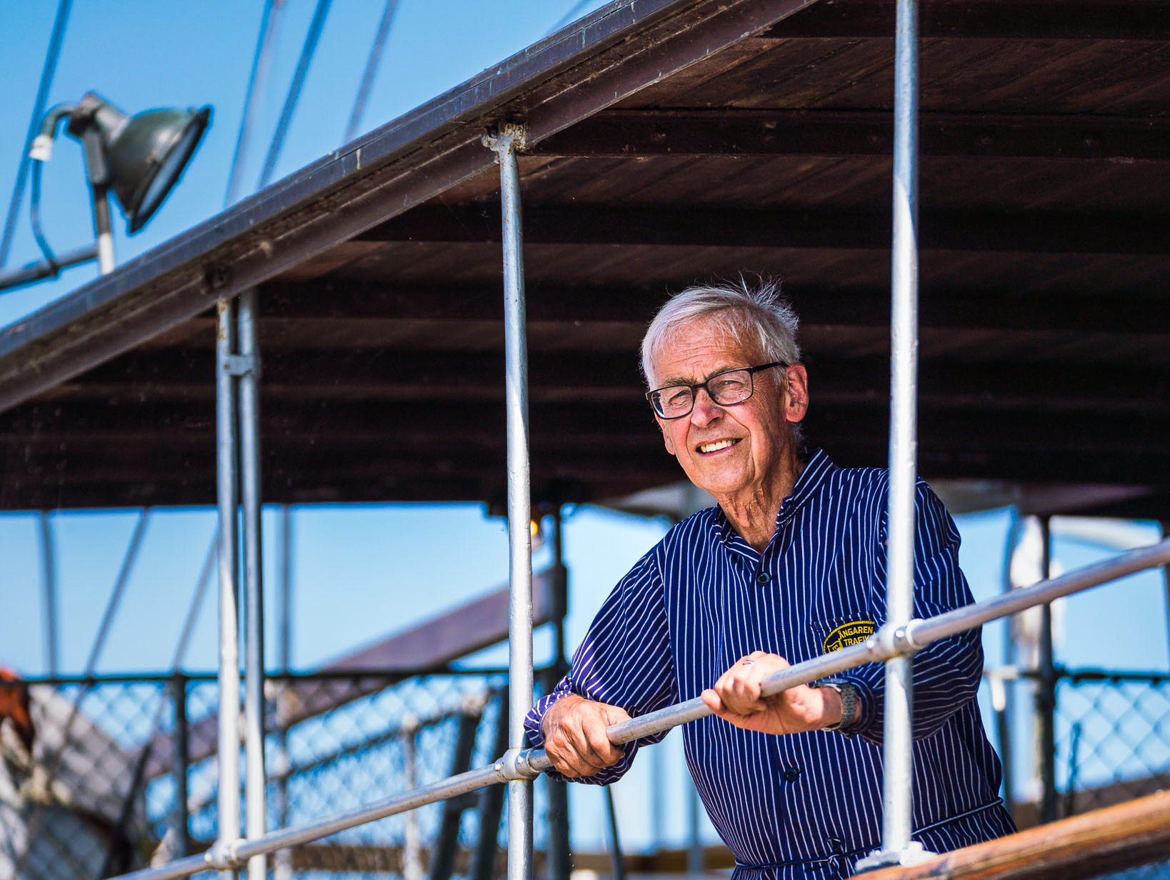 Maskinist ombord på ångaren Trafik blickar ut över Hjo hamn