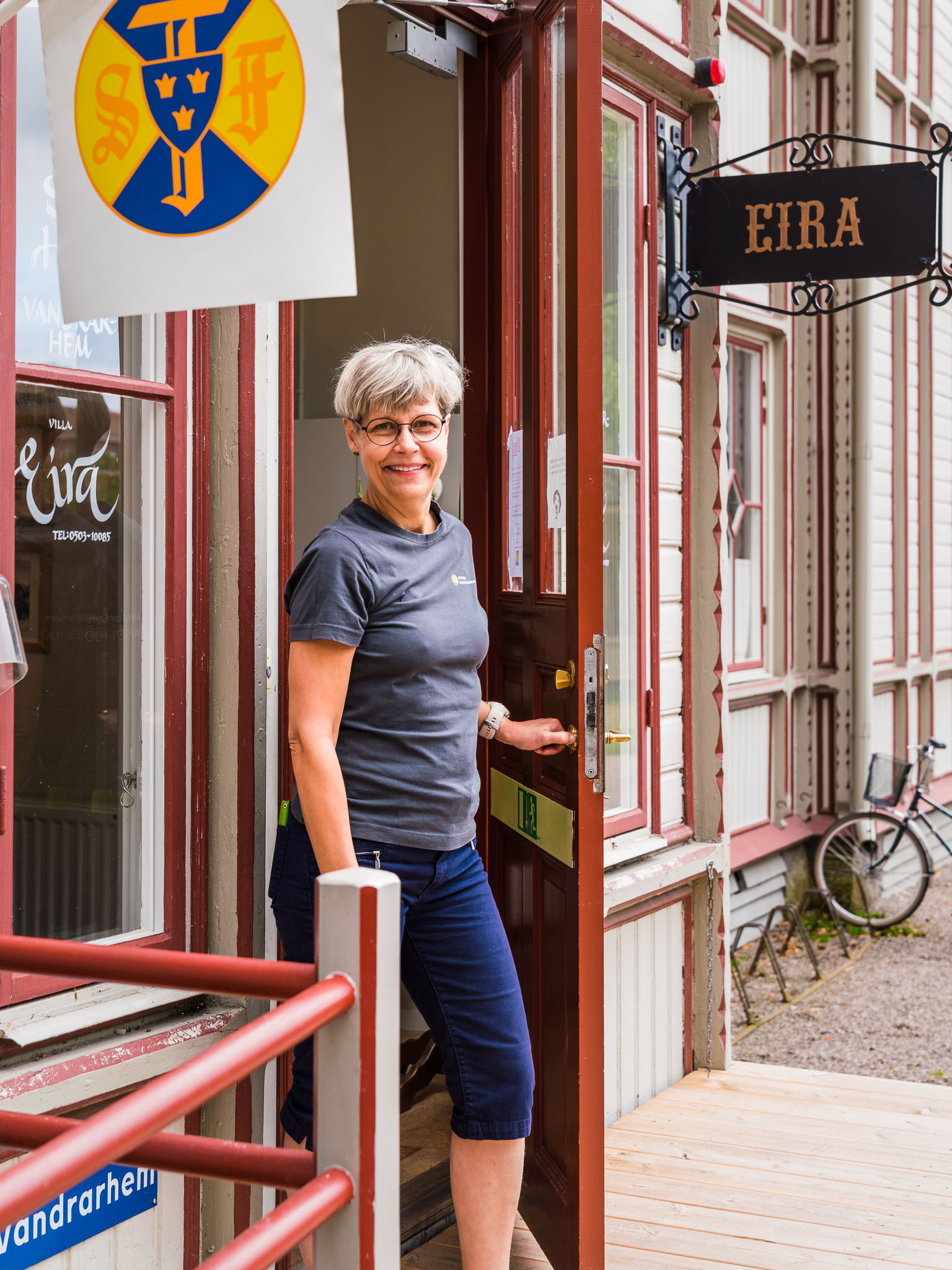 Ägare Lotta Nyberg i dörröppningen till STF Villa Eira i Hjo Stadspark. 