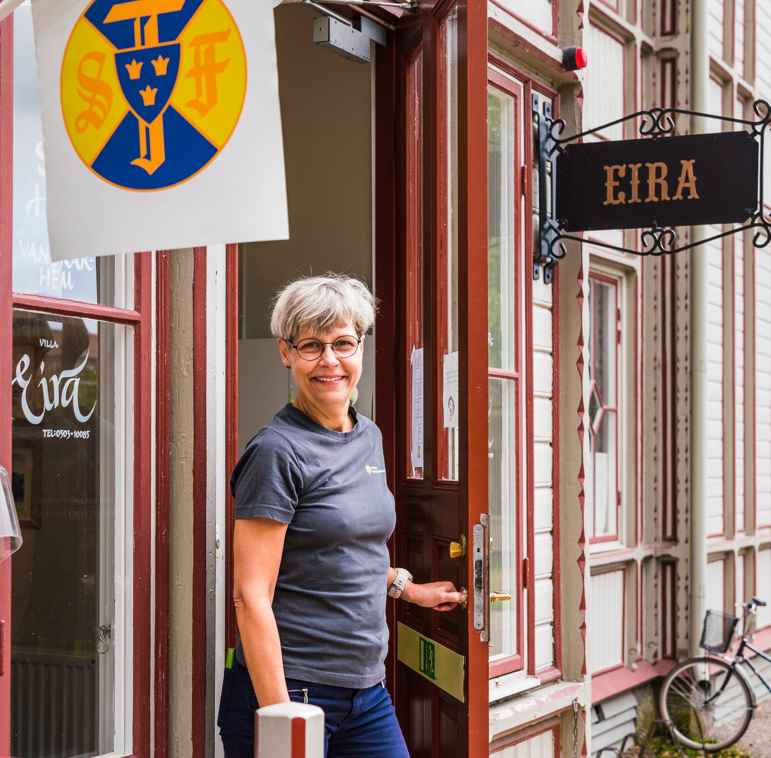 Ägare Lotta Nyberg i dörröppningen till STF Villa Eira i Hjo Stadspark. 