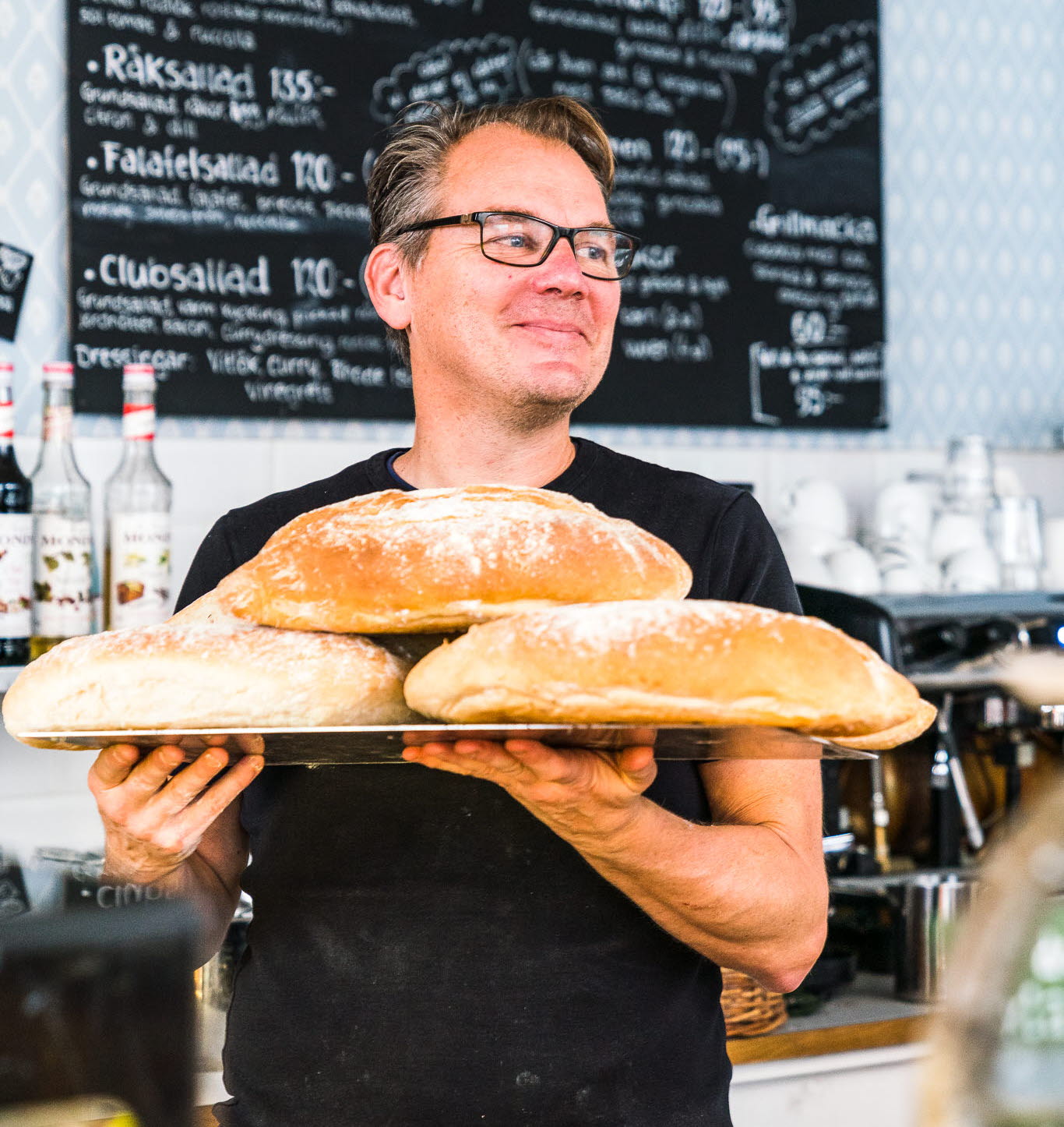 Kaféägare i Hjo med nybakat bröd inne på sitt café Vete & Råg. 