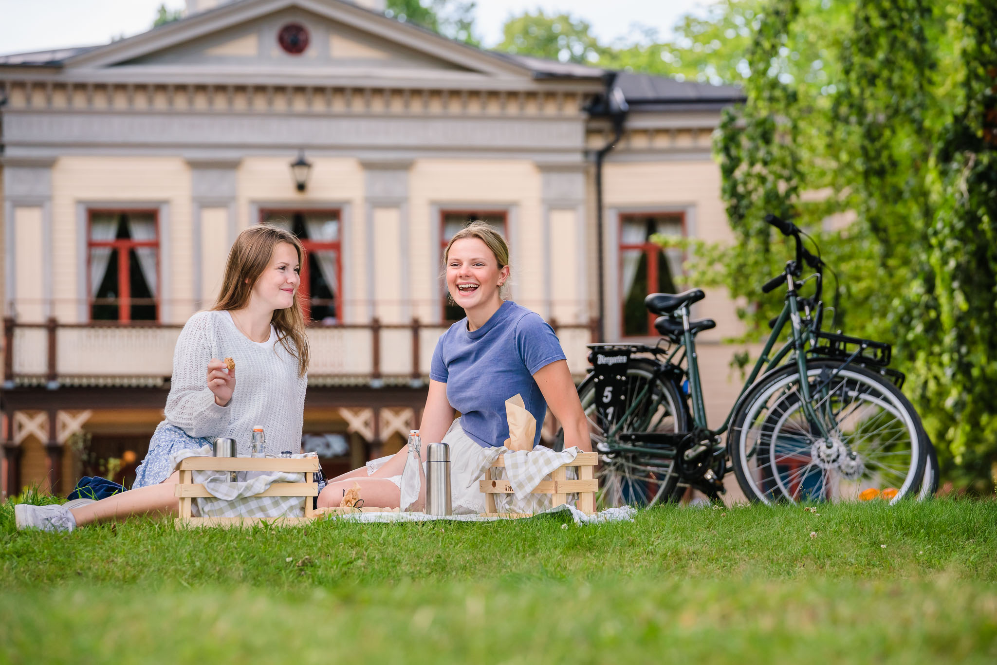 Två tonårstjejer har picknick i Hjo Stadspark.