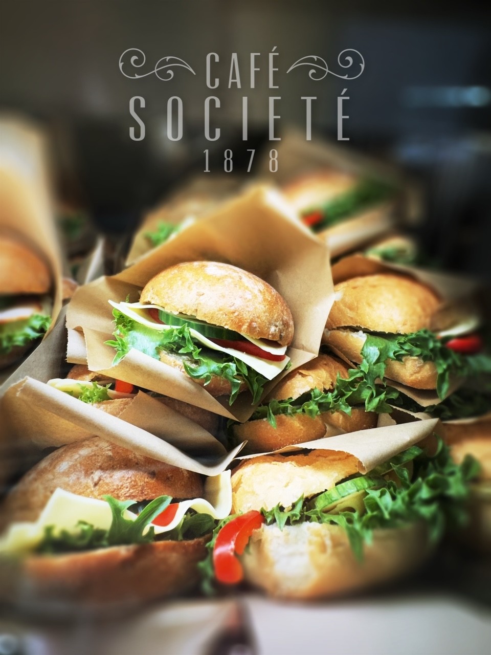 Smörgåsar med sallad och ost och grönsaker som står packade på varandra. 