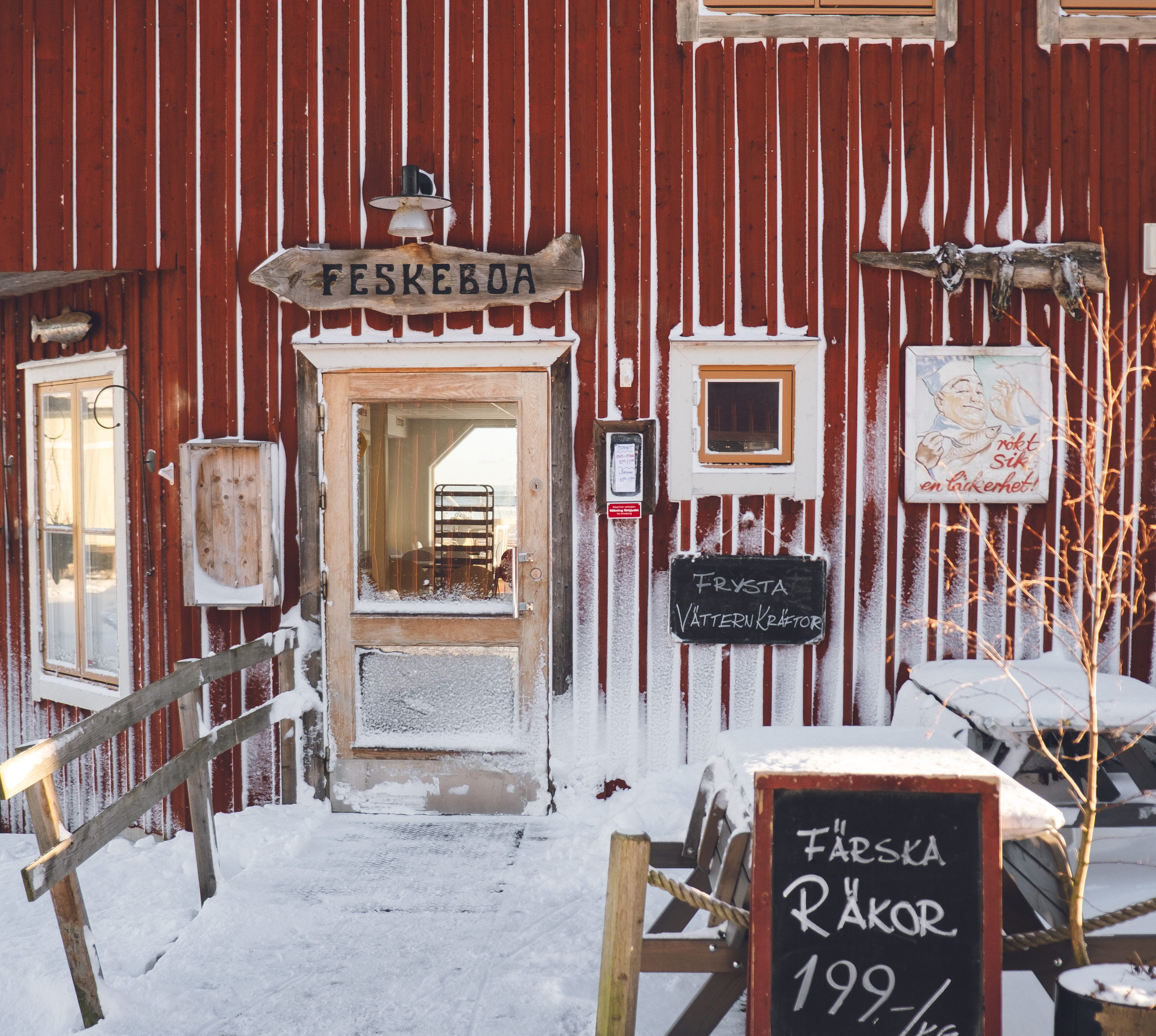 Rött trähus där en fiskehandlare hller till. Det är täckt med nö. 