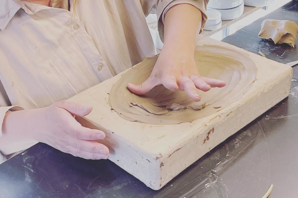 Händer knådar lera