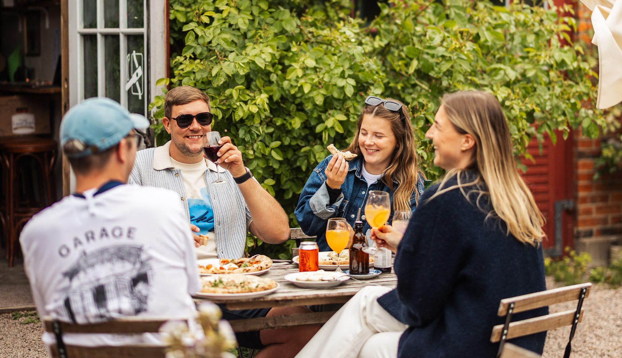 A group of people enjoying Hjo together with food, drinks, coffee and some shopping