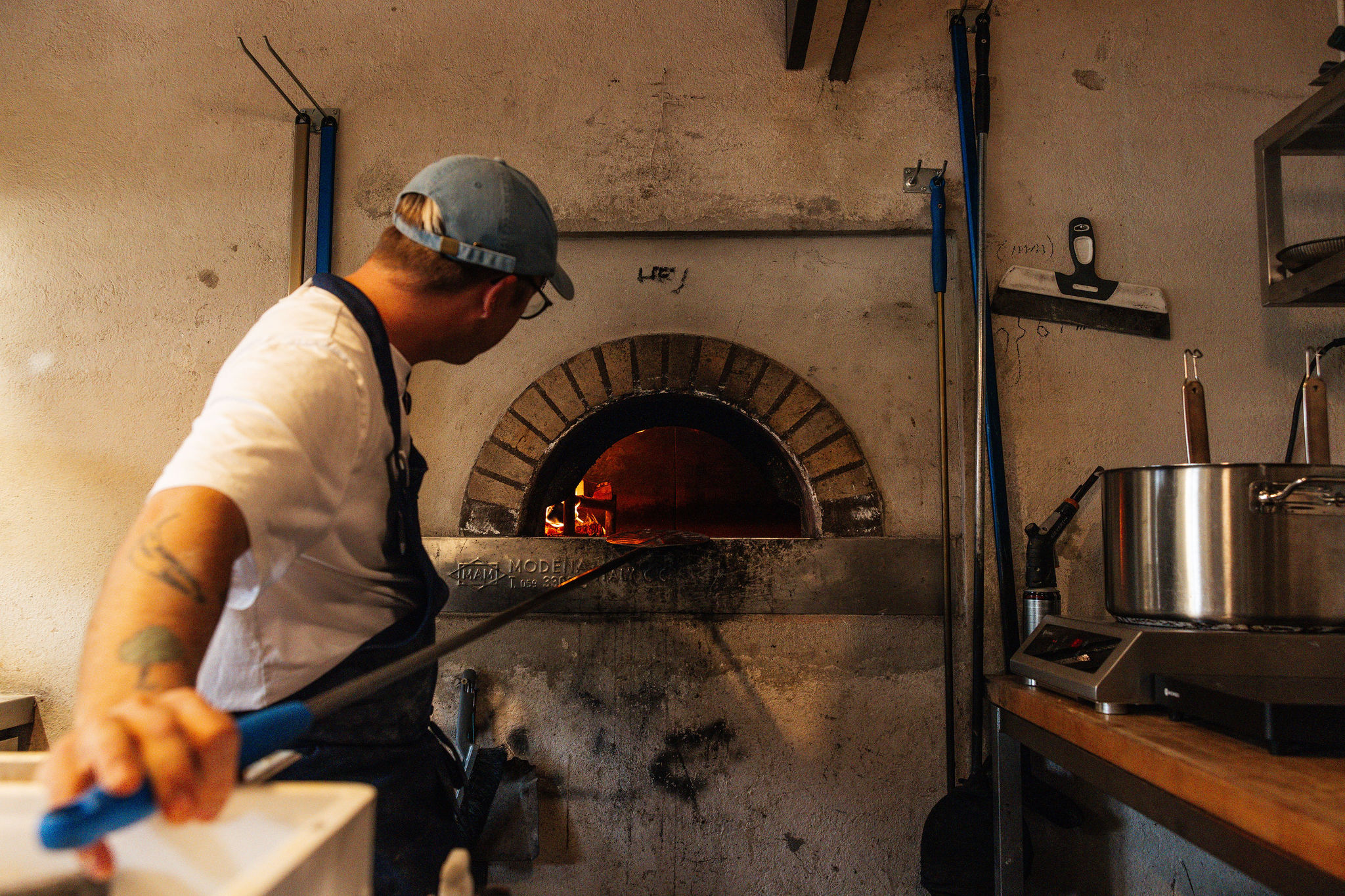 En kock lägger upp en nybakad pizza på en tallrik