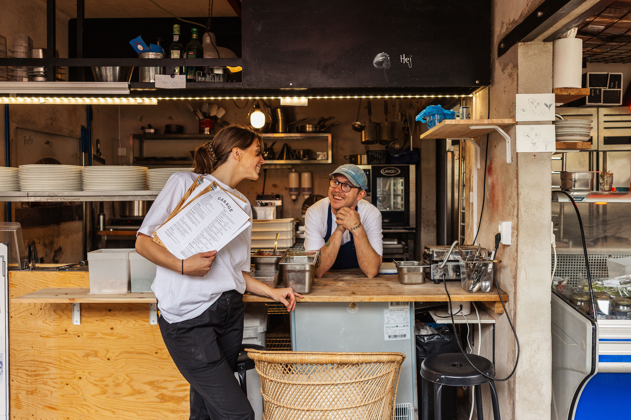 En kock lägger upp en nybakad pizza på en tallrik