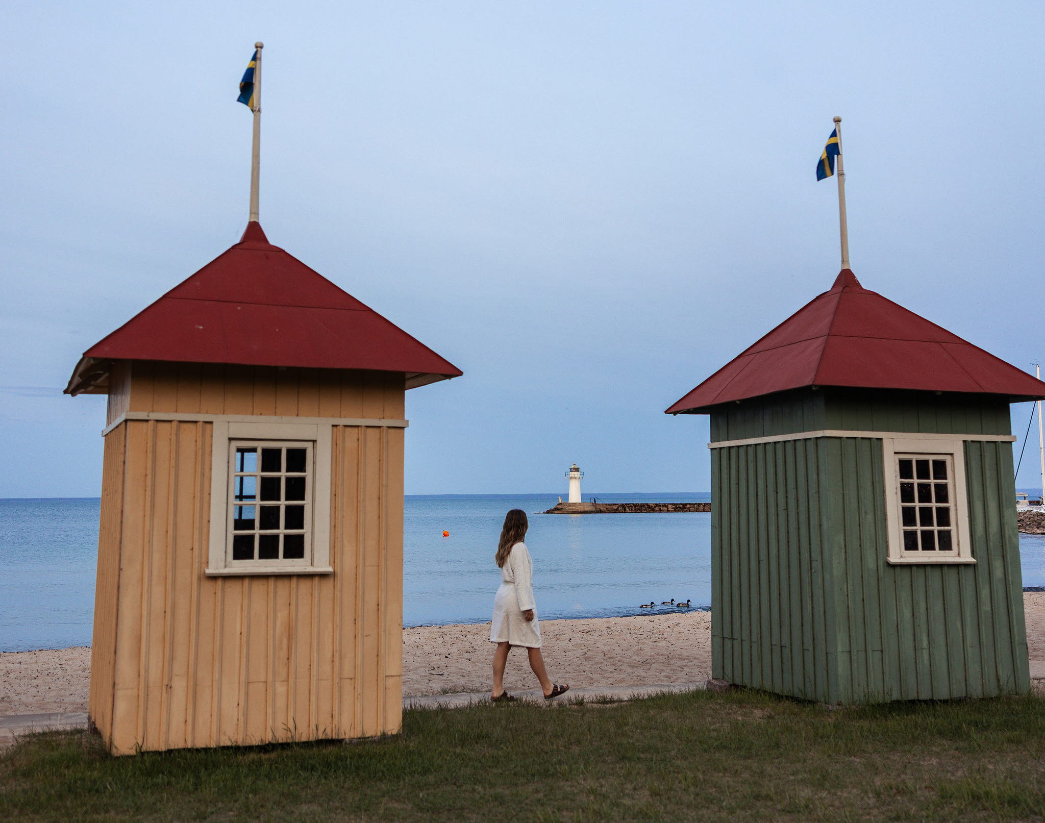 En grupp personer njuter av bastun vid Vätterns strand i Hjo