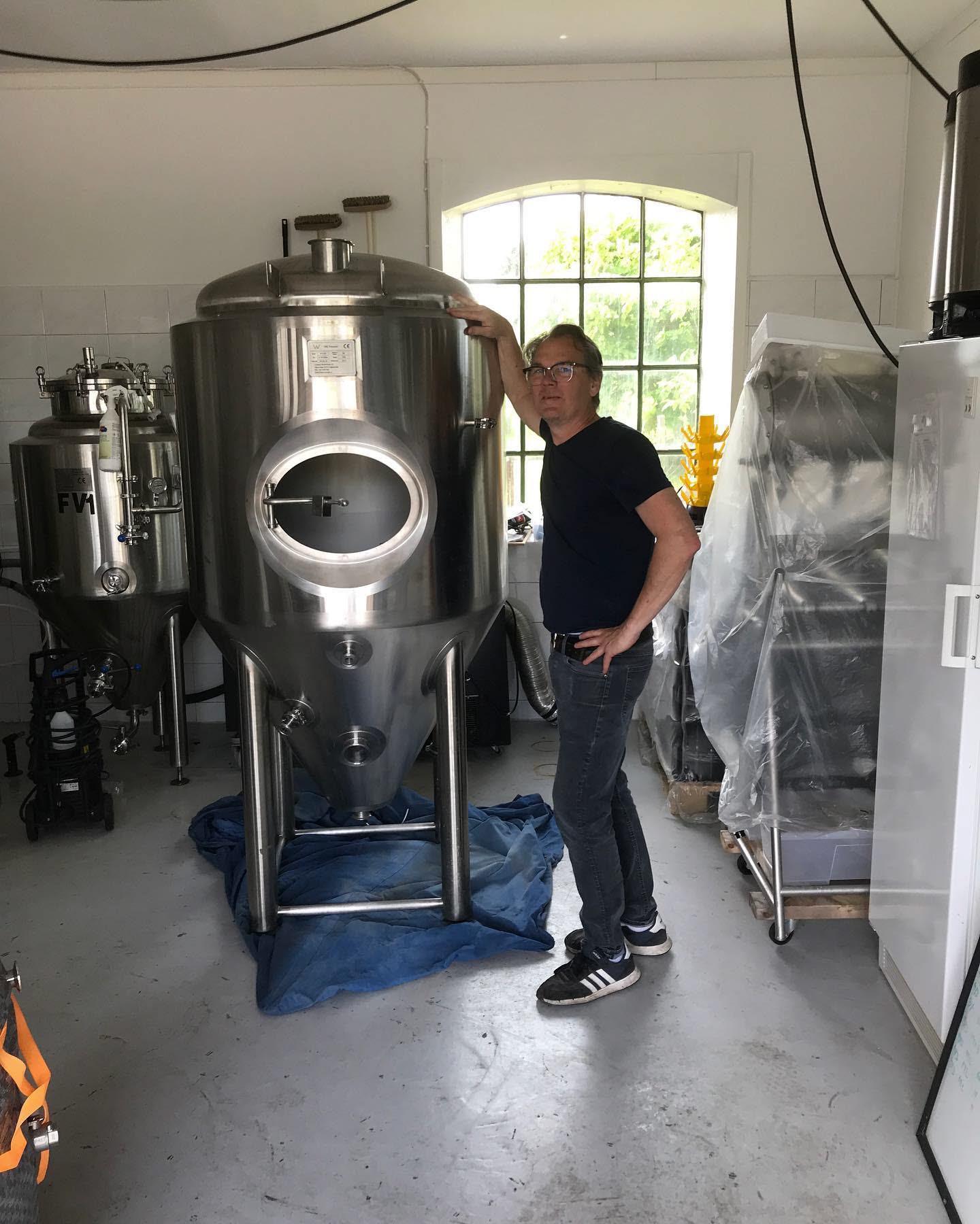 Erik, bryggaren på Guldkrokens bryggeri, står intill en av bryggeriets tankar. 