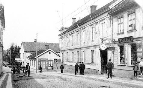 Gammalt fotografi som visar stadslivet i Hjo - Hamngatan. 