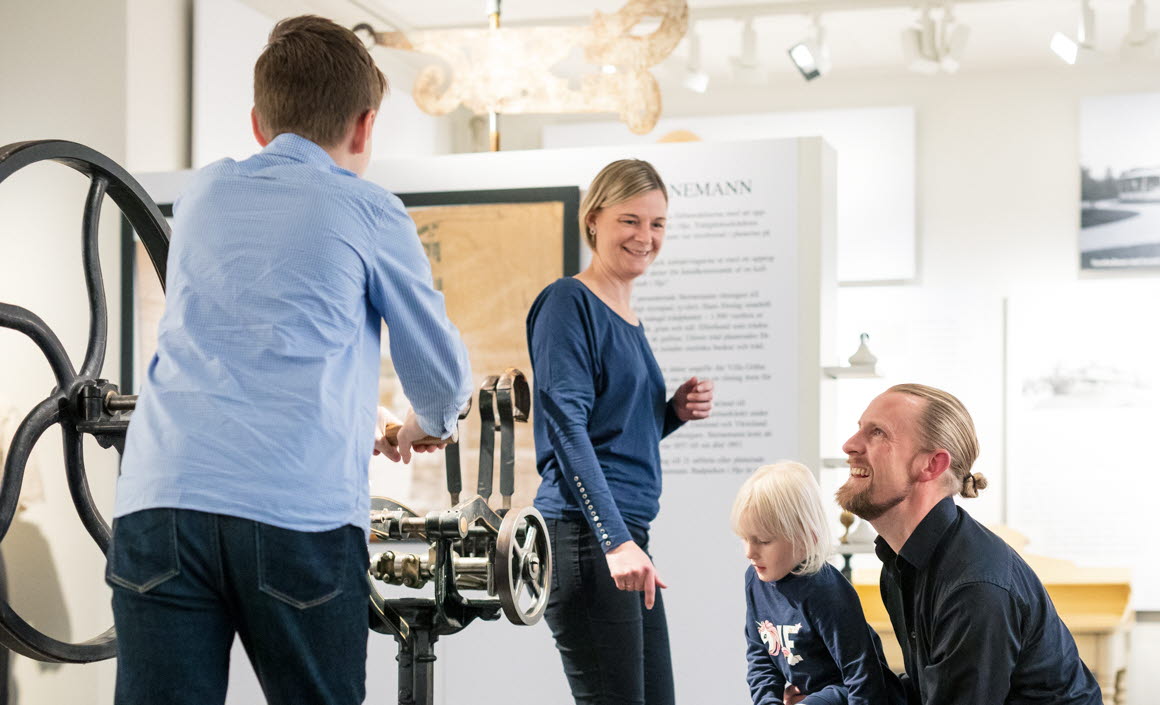 Familj i historisk utställning inne på Kulturkvarteret i Hjo. 