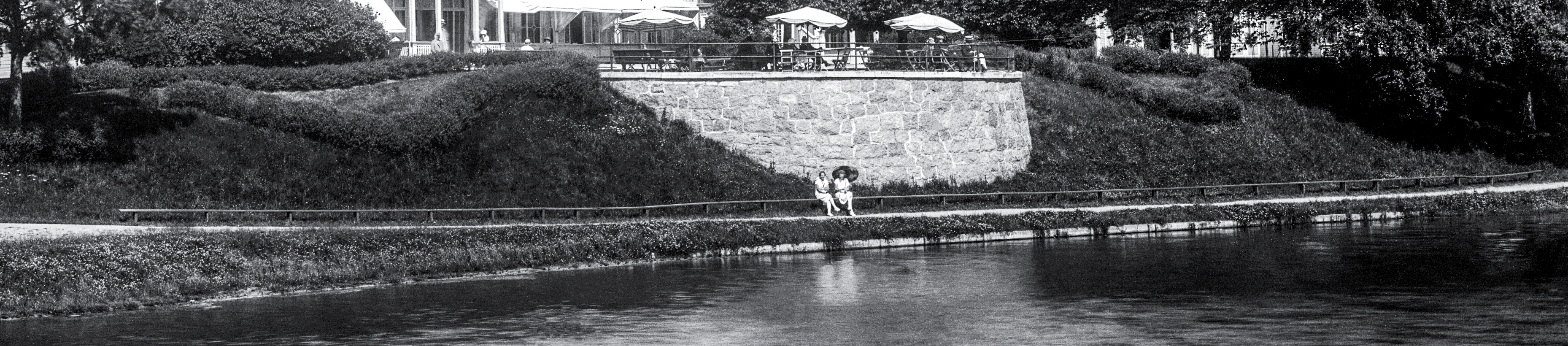 Kvinna sitter nedanför Bellevueterassen, på Hjos gamla långbänk.