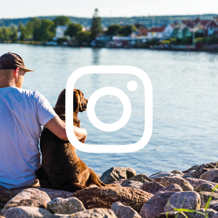 Guy and dog sitting in the harbour in Hjo. 