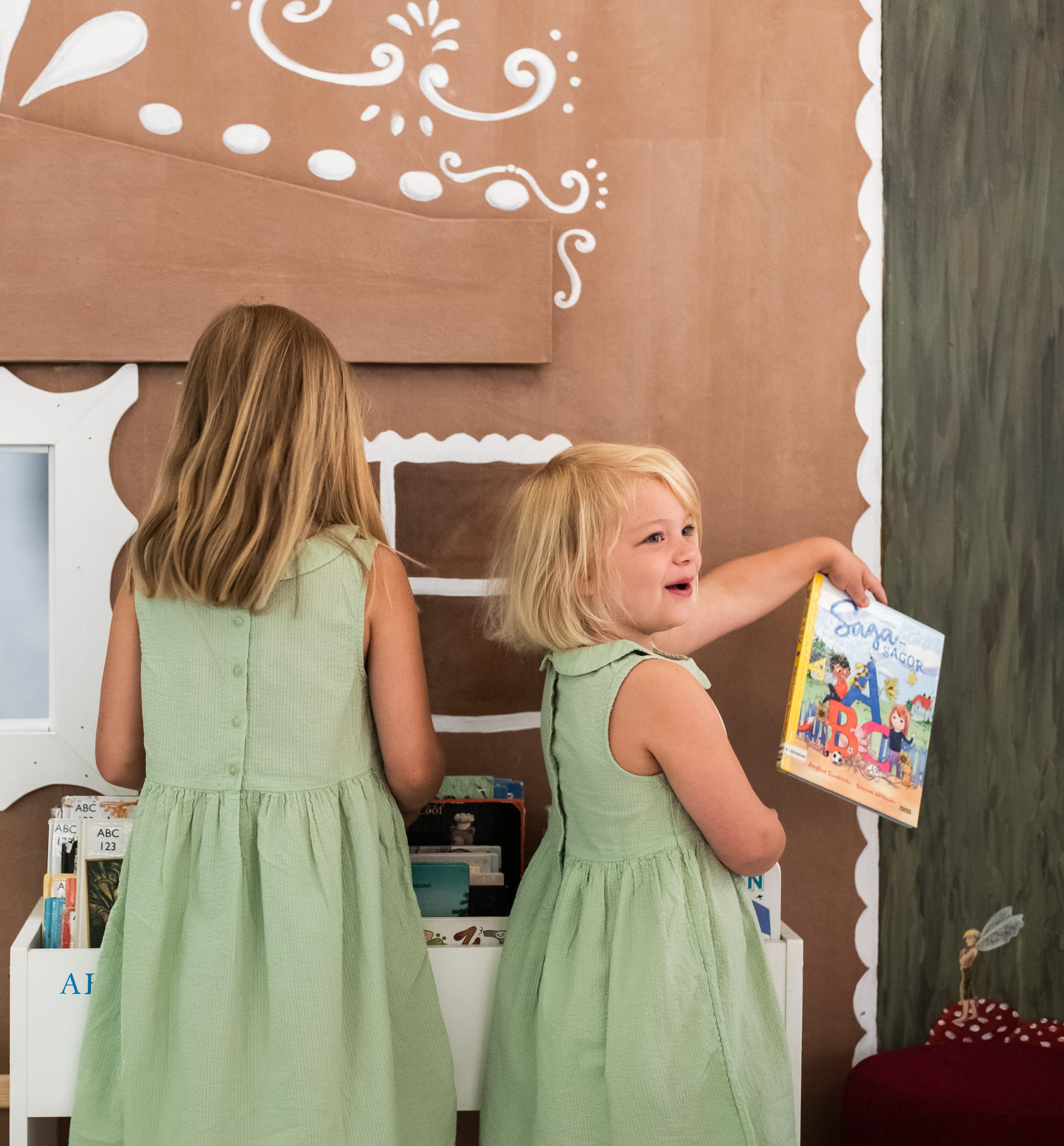 Två barn letar efter böcker på ett bibliotek. 