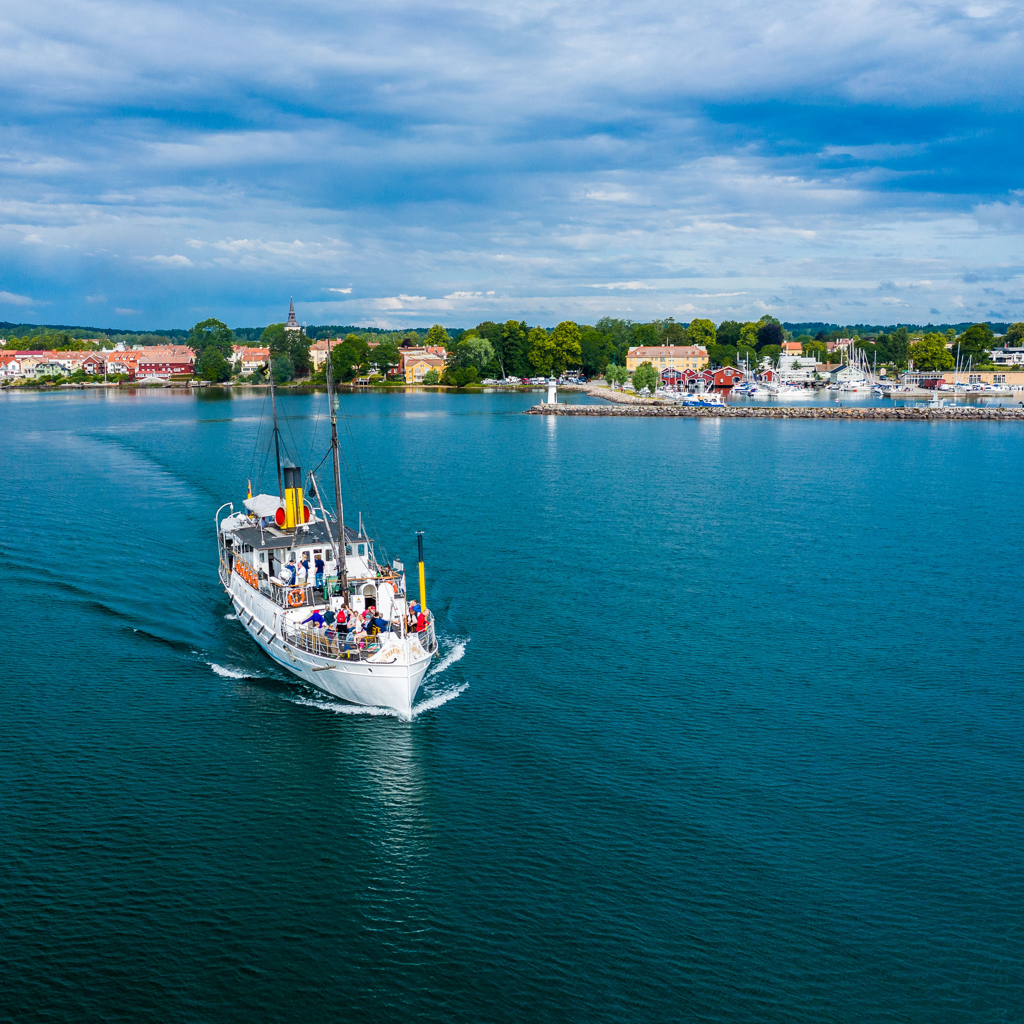 Ångaren Trafik lämnar Hjo och beger sig ut på Vättern, med Hjo stad i bakgrunden. 