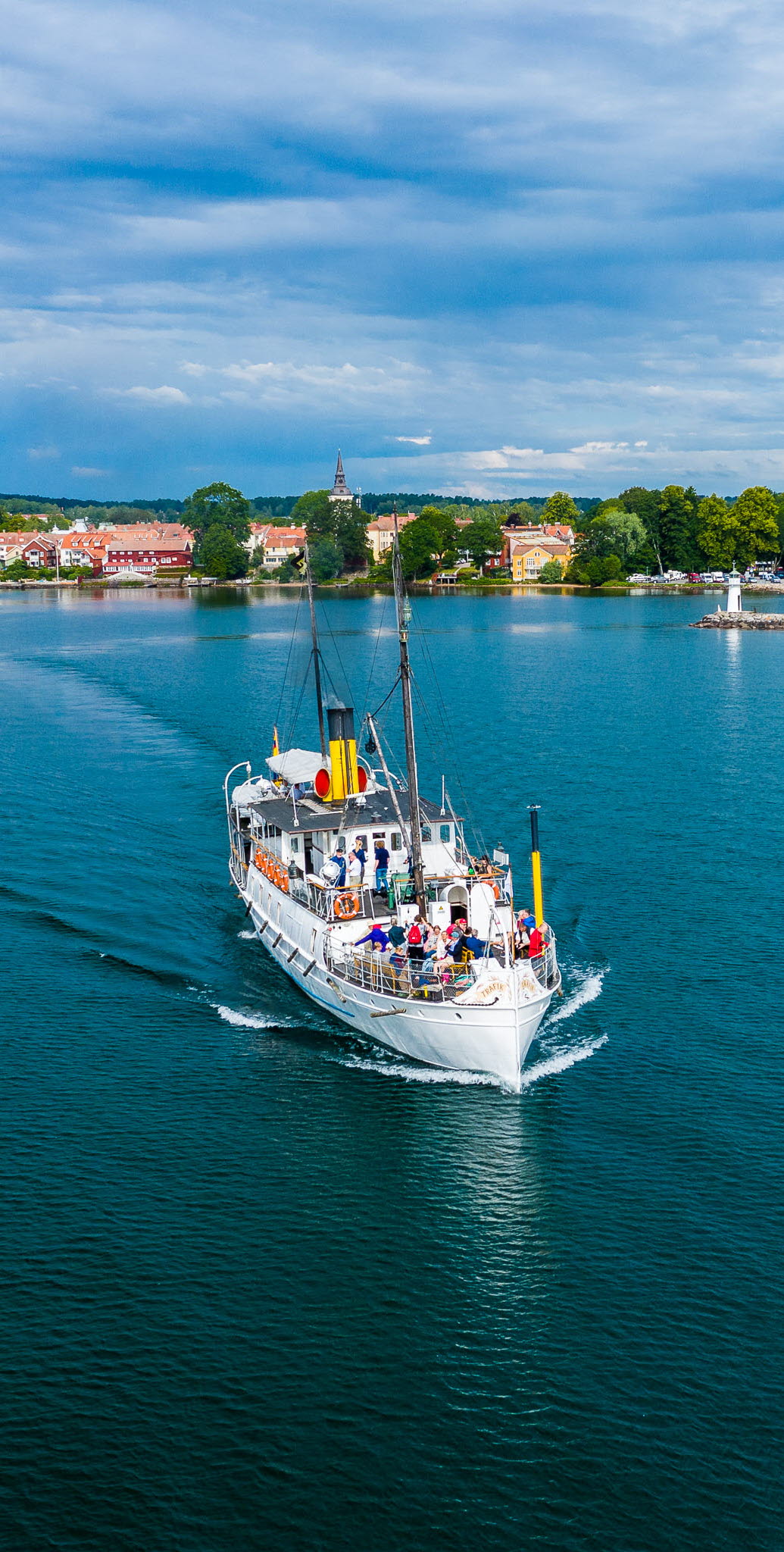 Ångaren Trafik avreser från Hjo hamn, med Hjo stad i bakgrunden. 