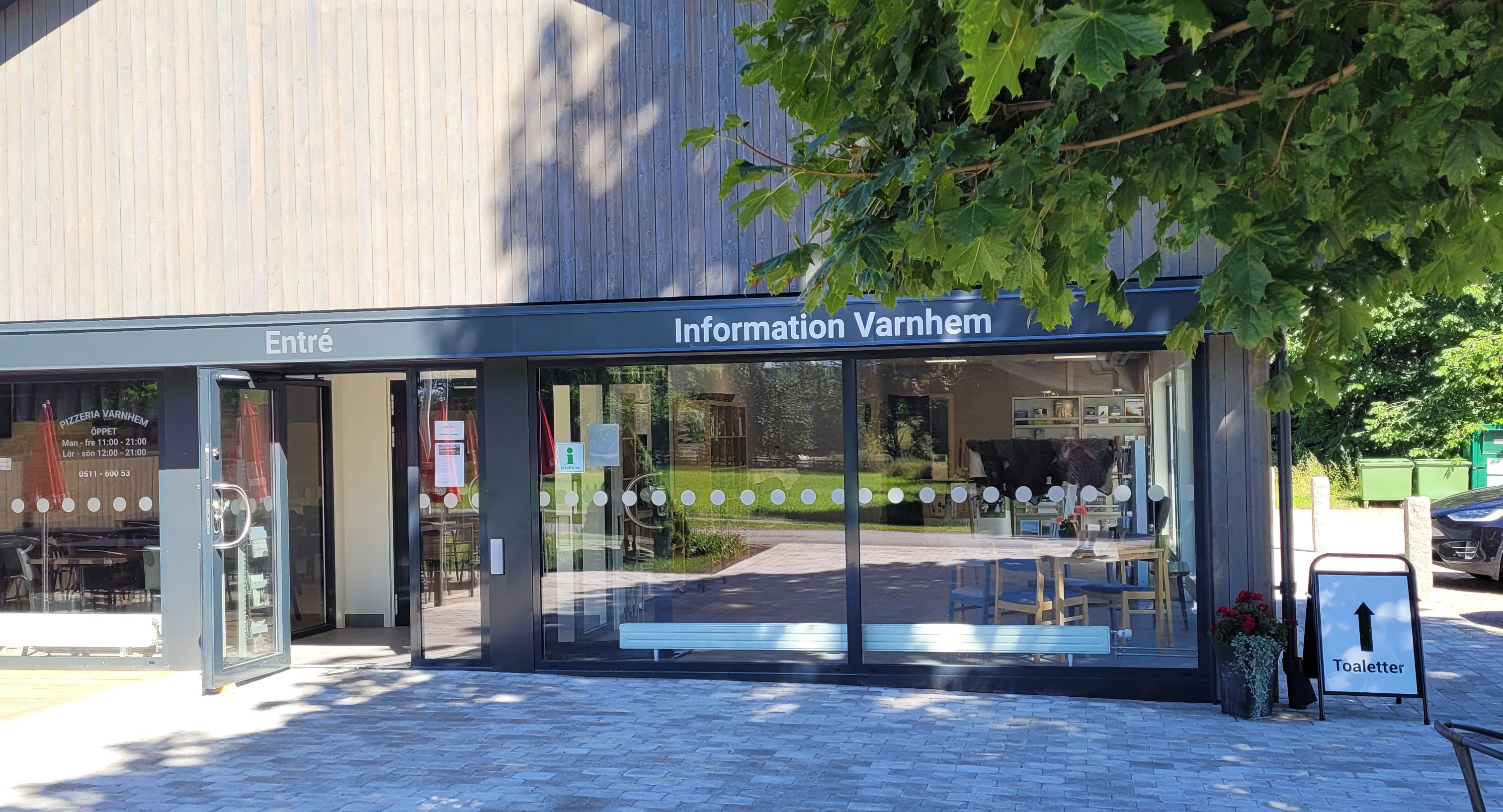 Grå byggnad med stora glasrutor.