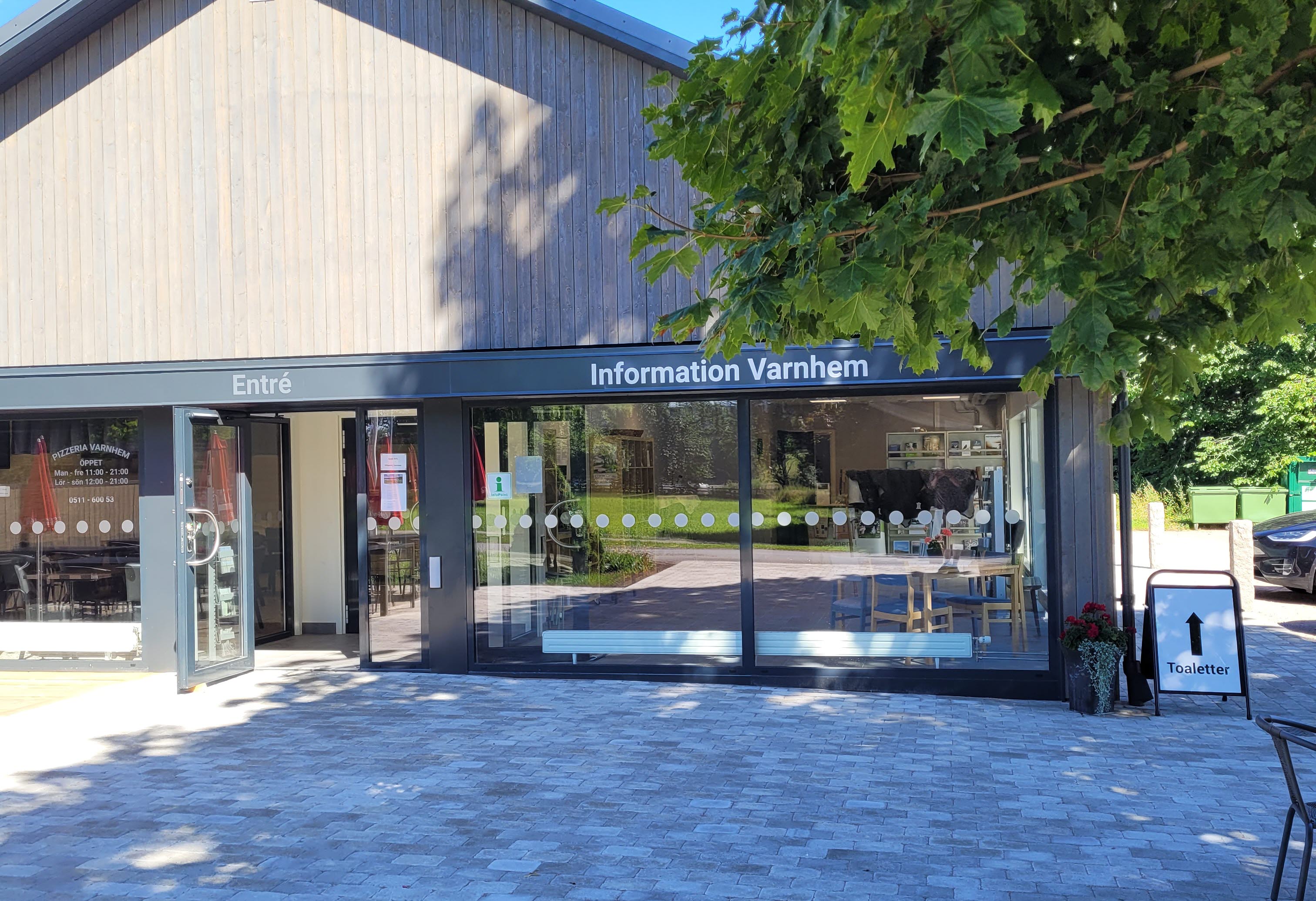 Grå byggnad med stora glasrutor.