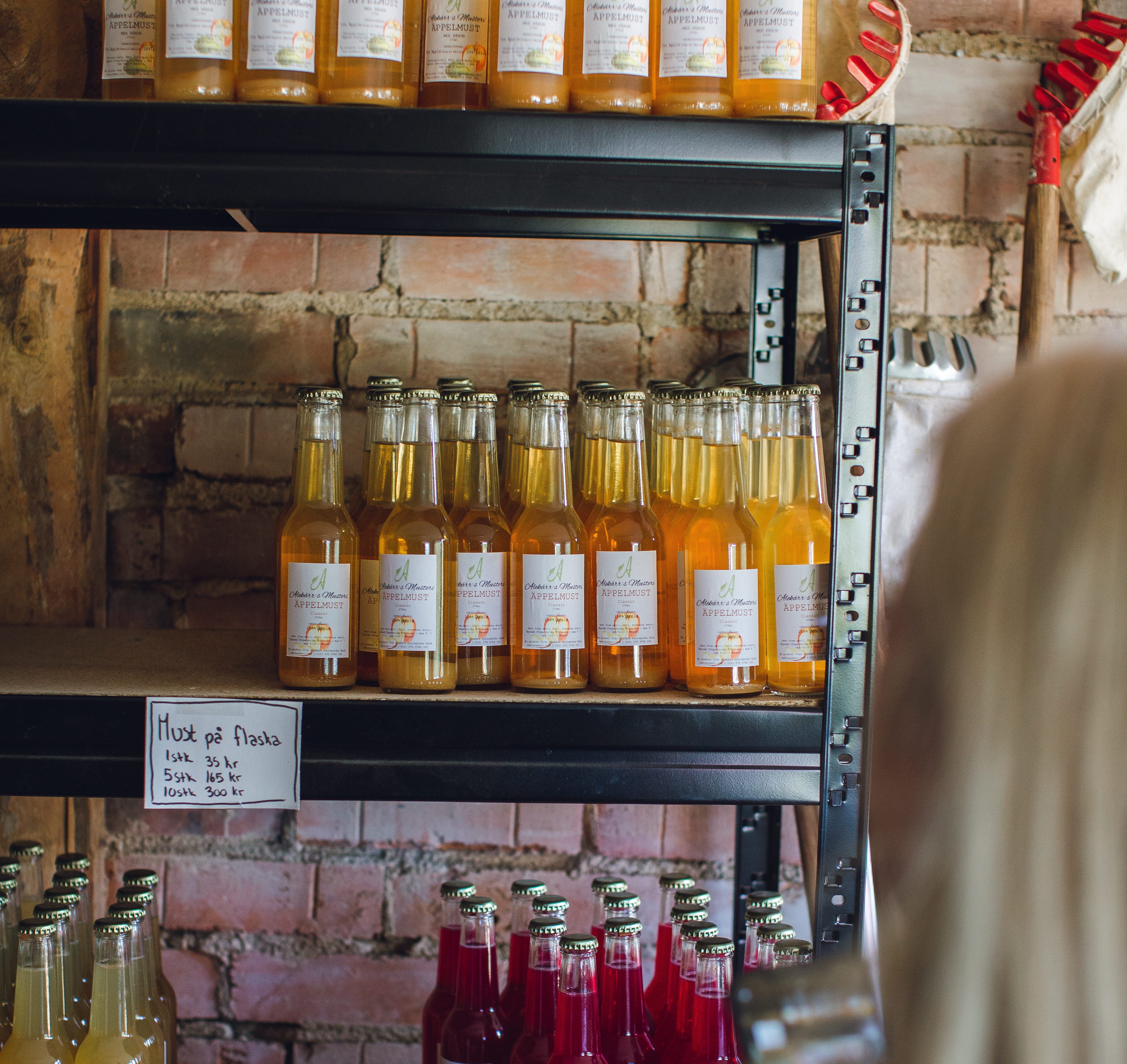 en hylla med flaskor med äppelmust. 