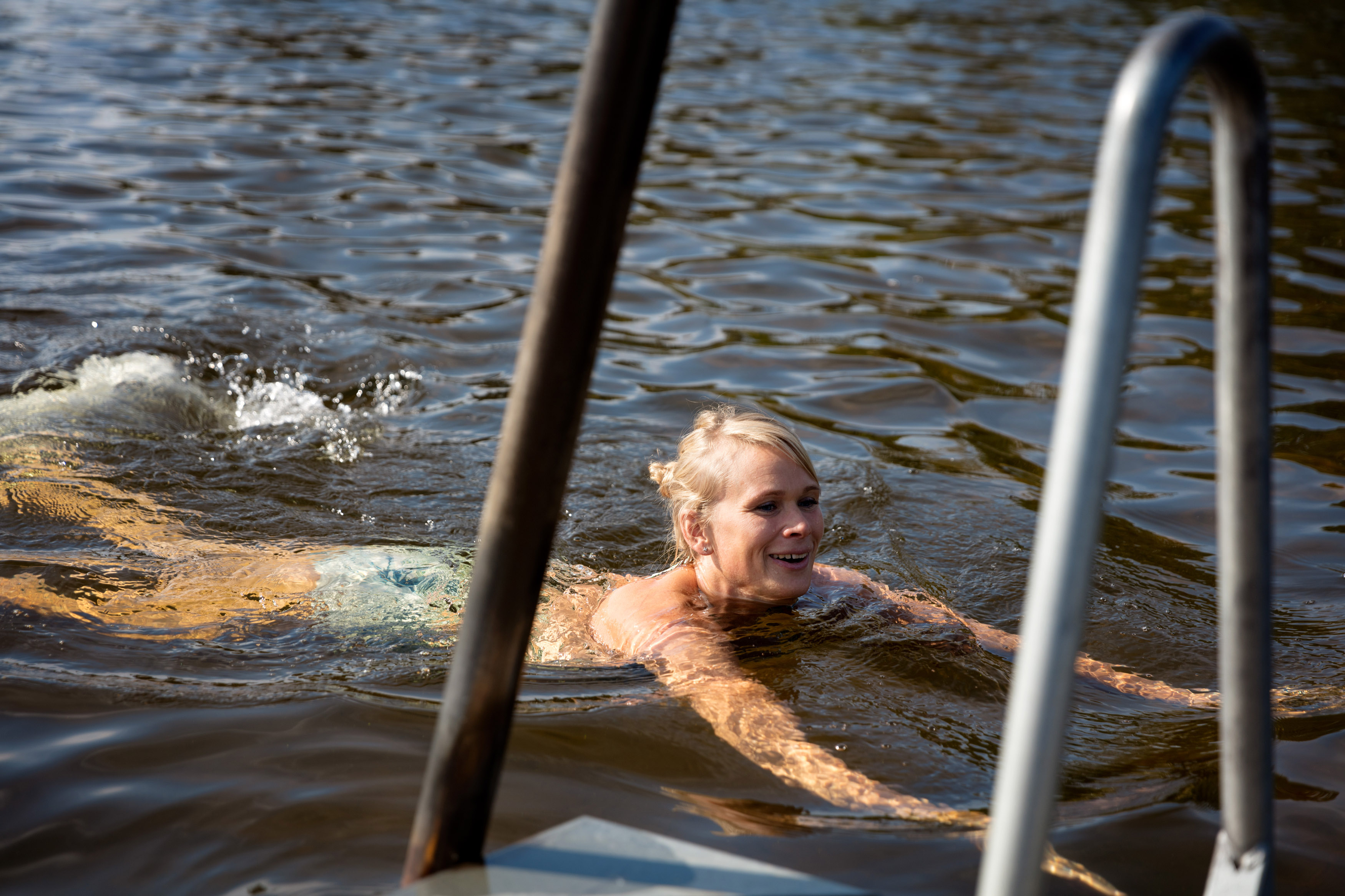 En kvinna simmar vid en brygga
