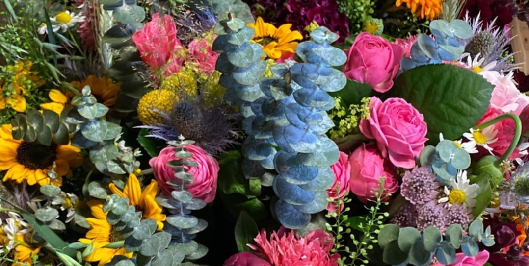 Närbild på en bukett med rosa, gula och gröna blommor. 