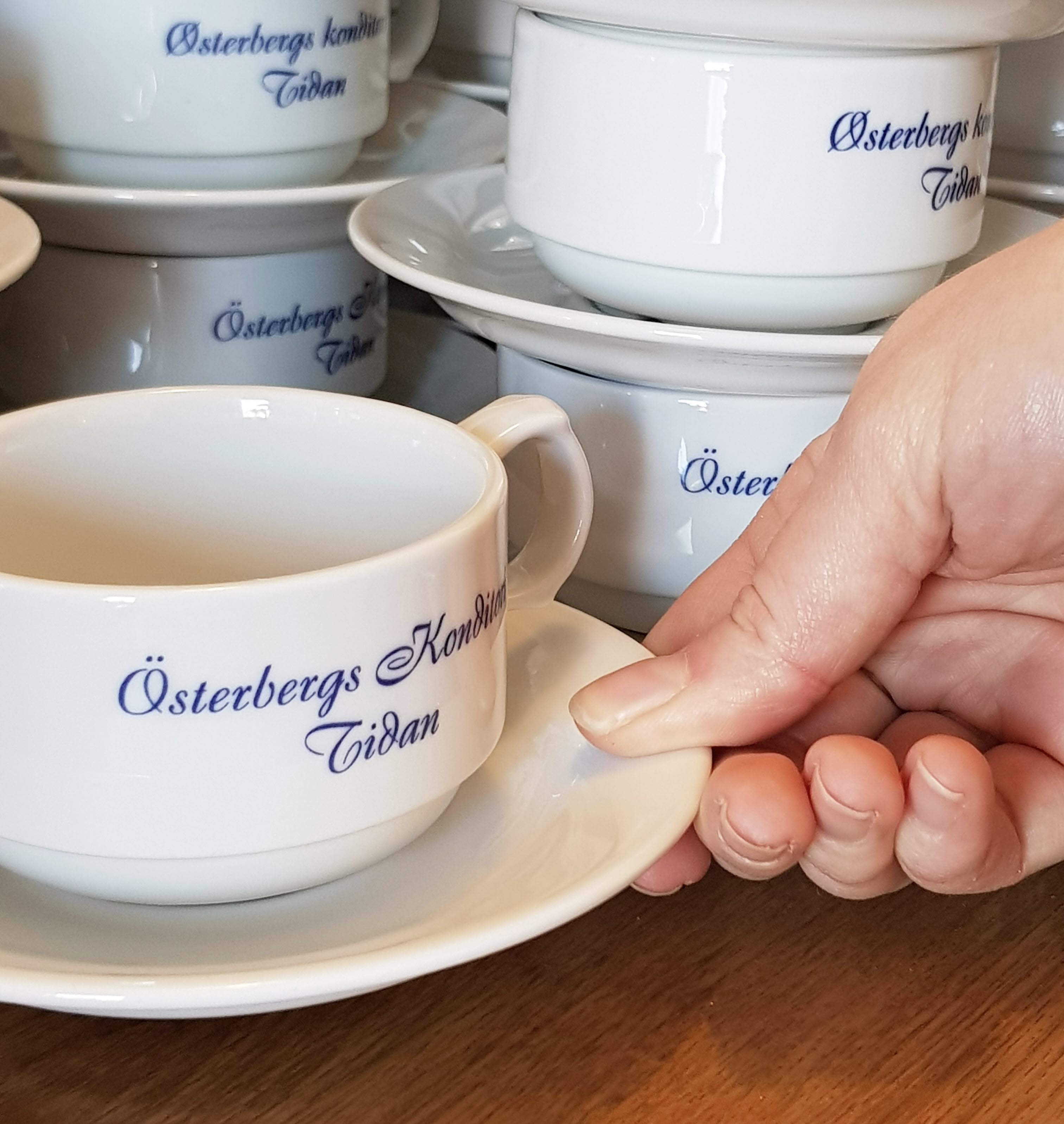 Vita koppar och fat står staplade på varandra.