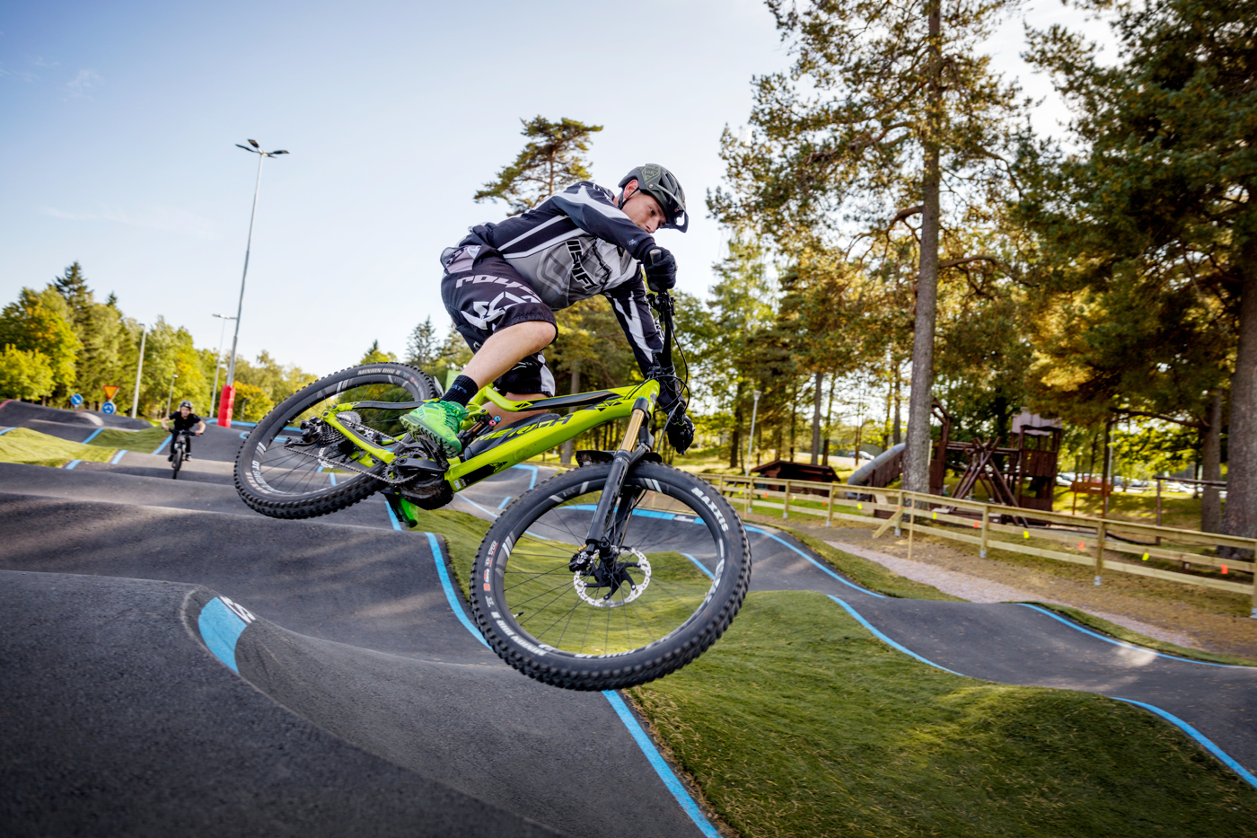 En man hoppar i luften med sin gröna cykel i Billingens Bikepark 