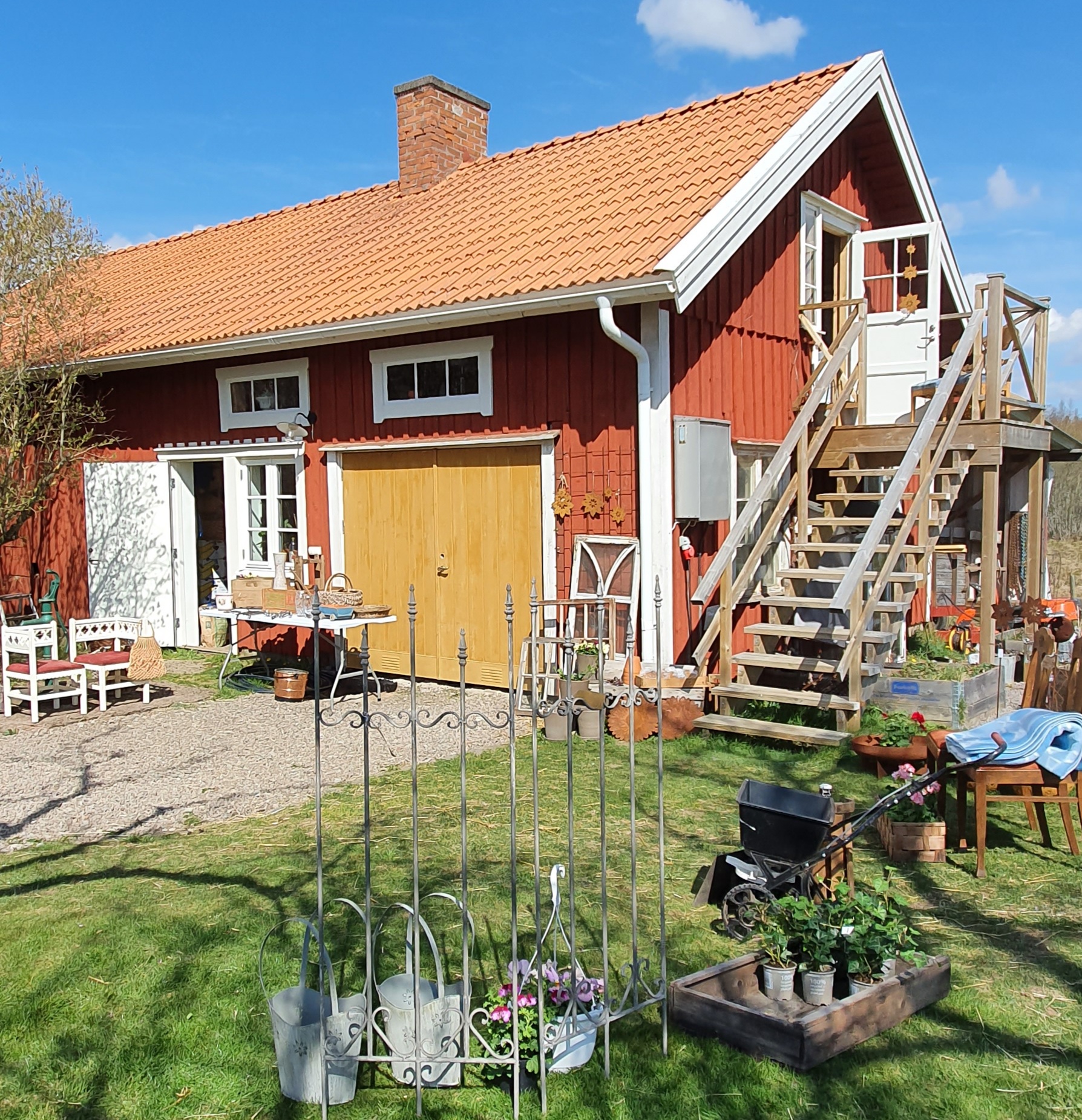 Red cottage with garden products outside.