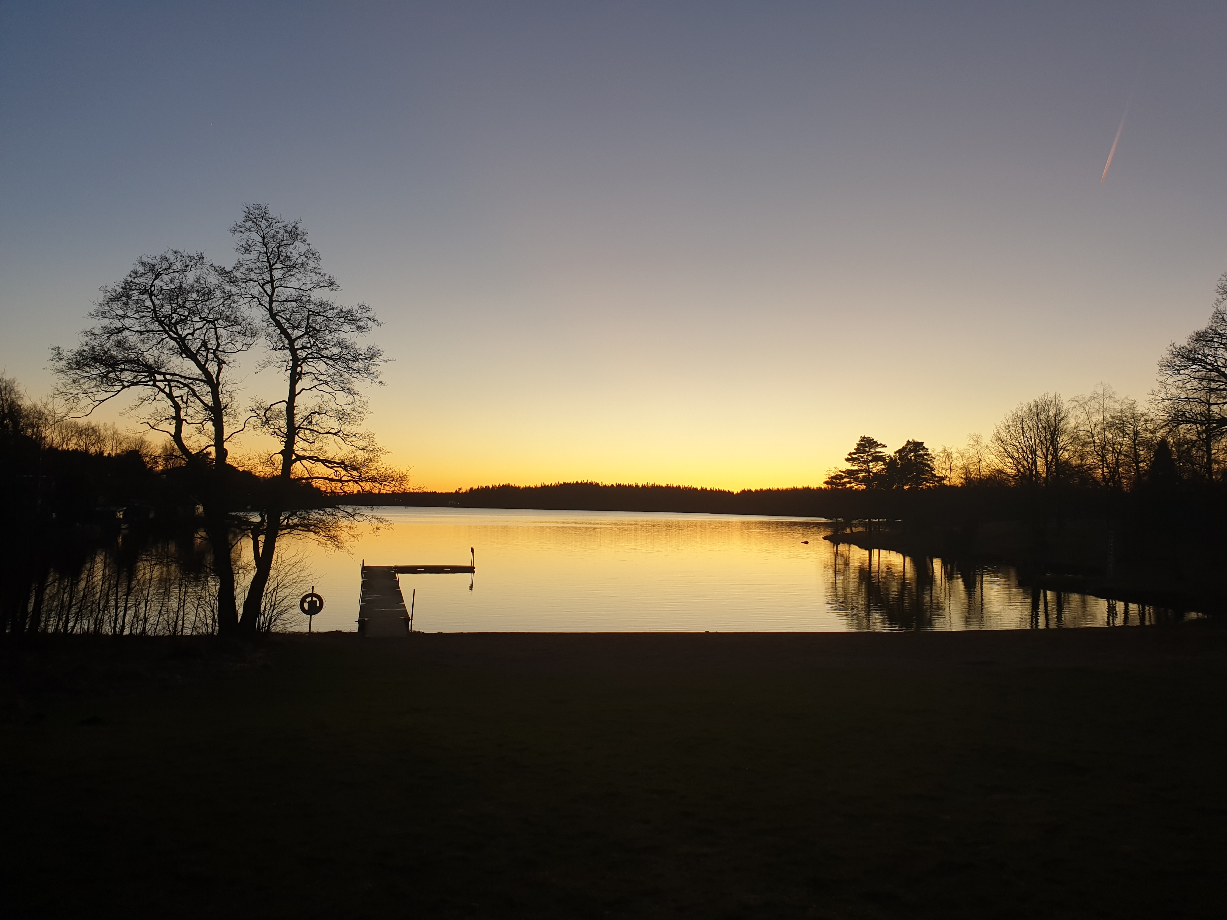 Sunset one spring evening over a bathing area with jetty.
