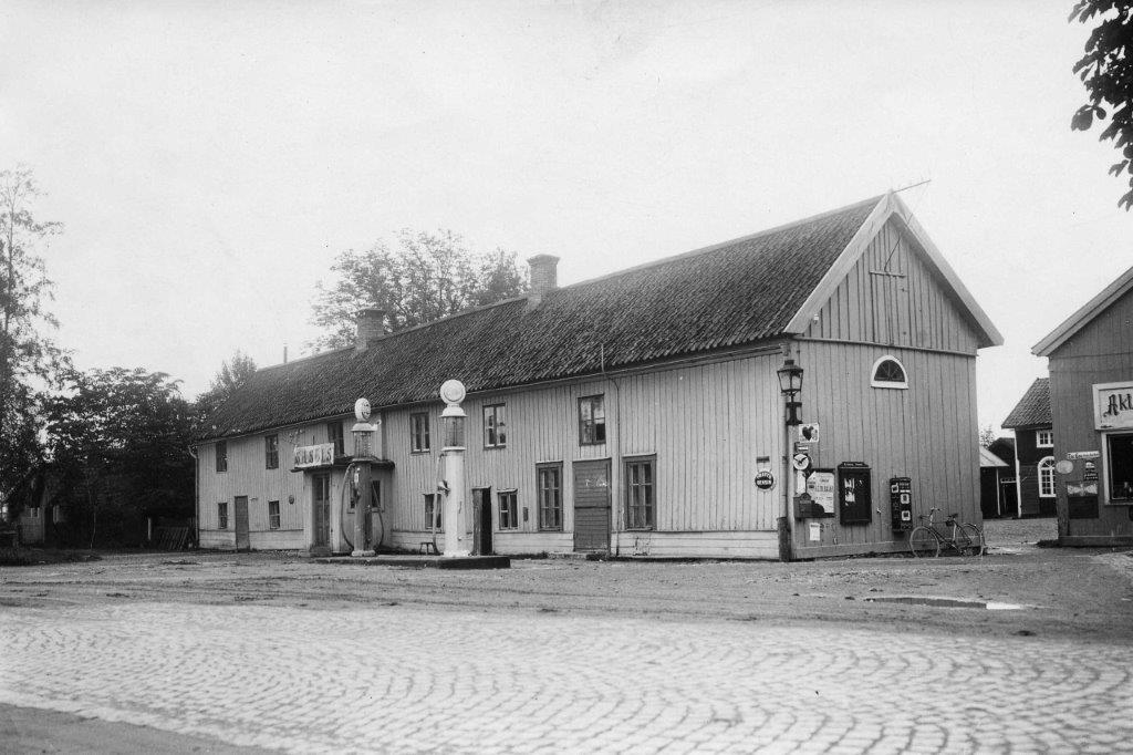 Black and white archive image of a cobblestone square in front of an elongated building.