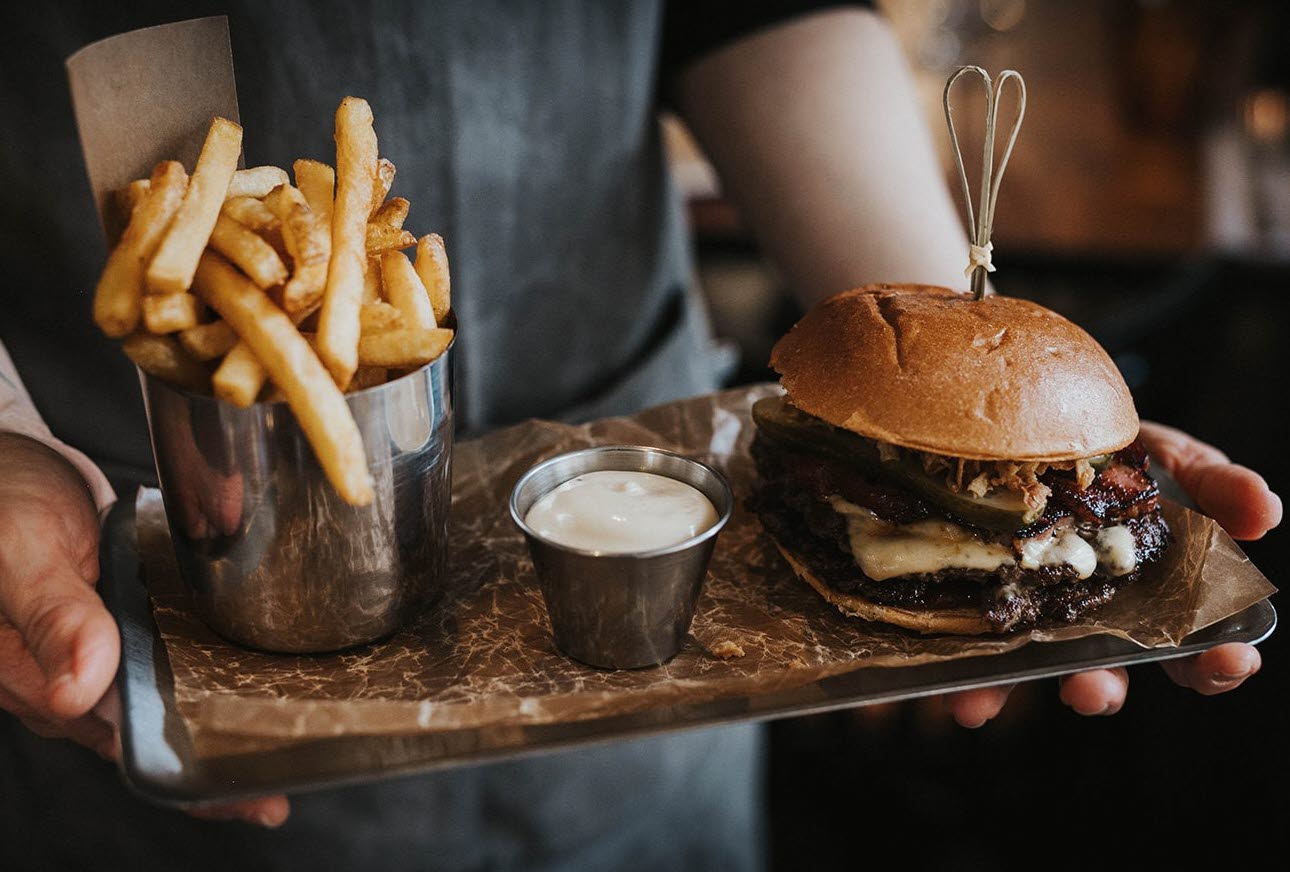 Hamburgare och pommes upplagda på en bricka