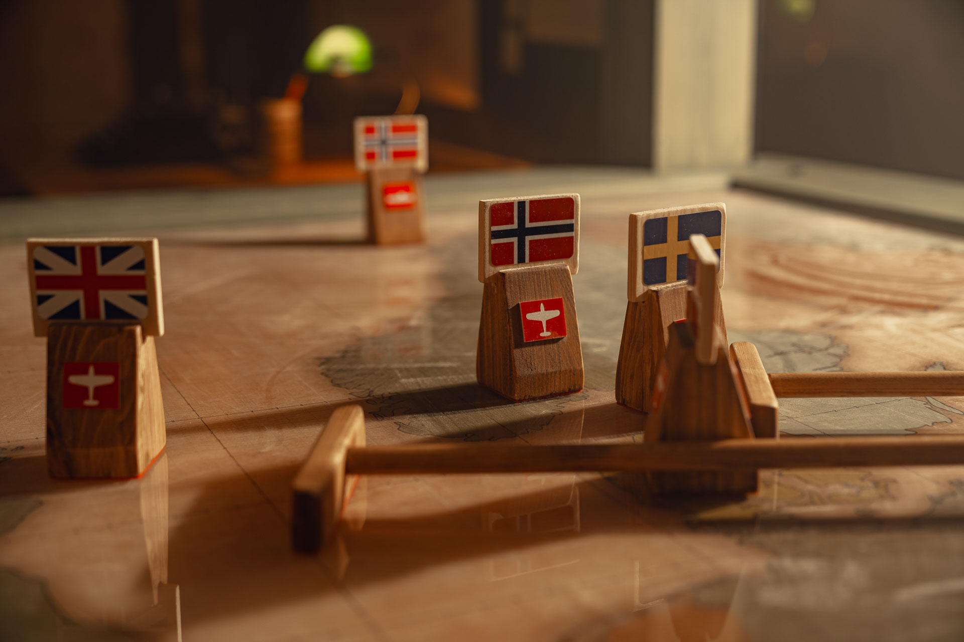 Flaggmarkörer med Storbritanniens, Norge och Sveriges flaggor på ett bord med kartbild.