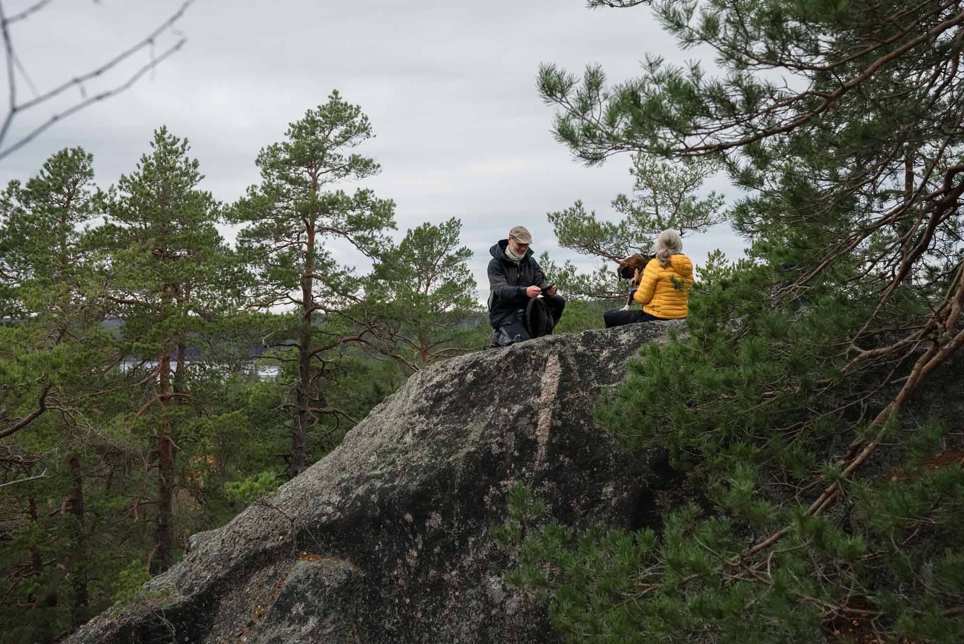 Kvinna och man sitter på ett mindre berg.