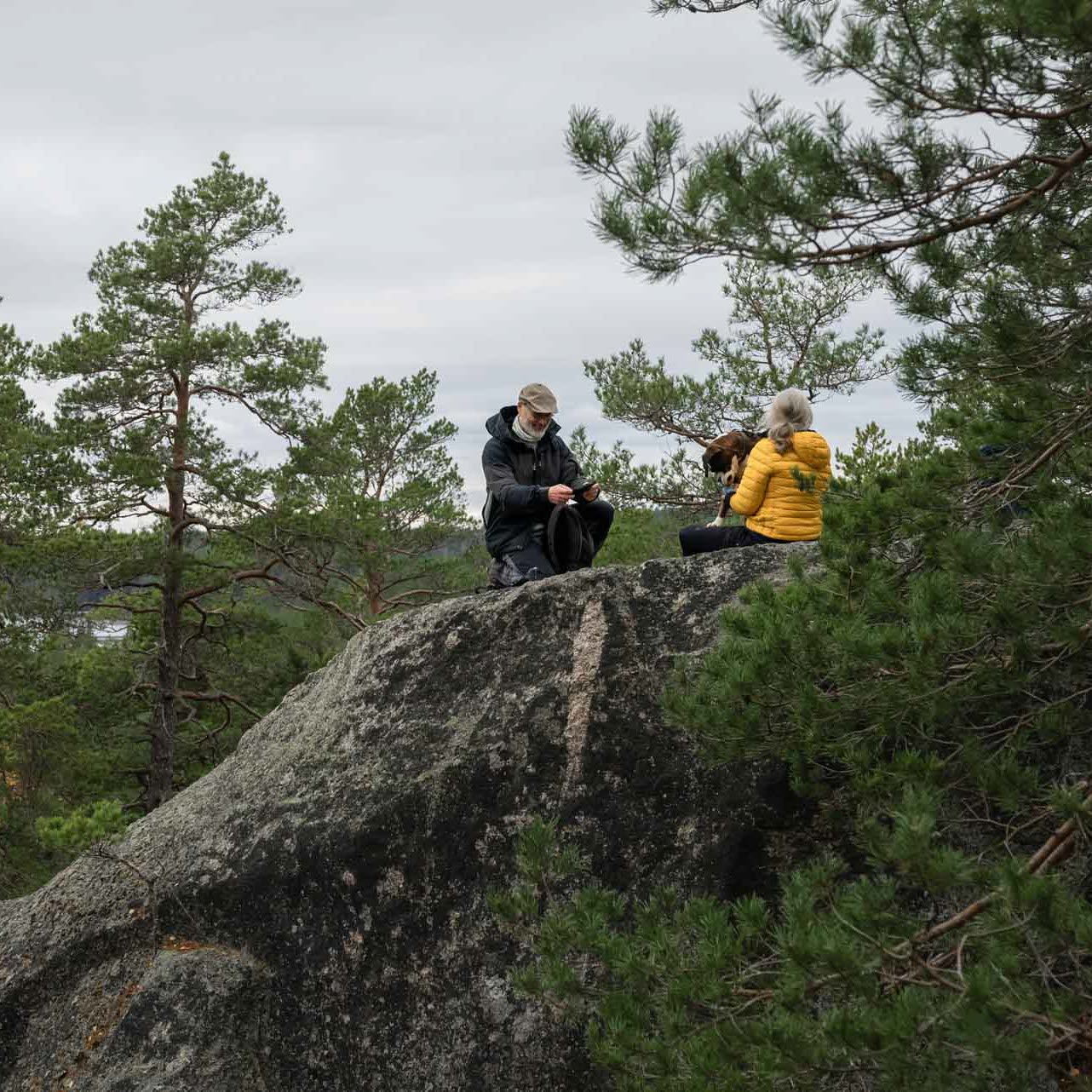 Kvinna och man sitter på ett mindre berg.