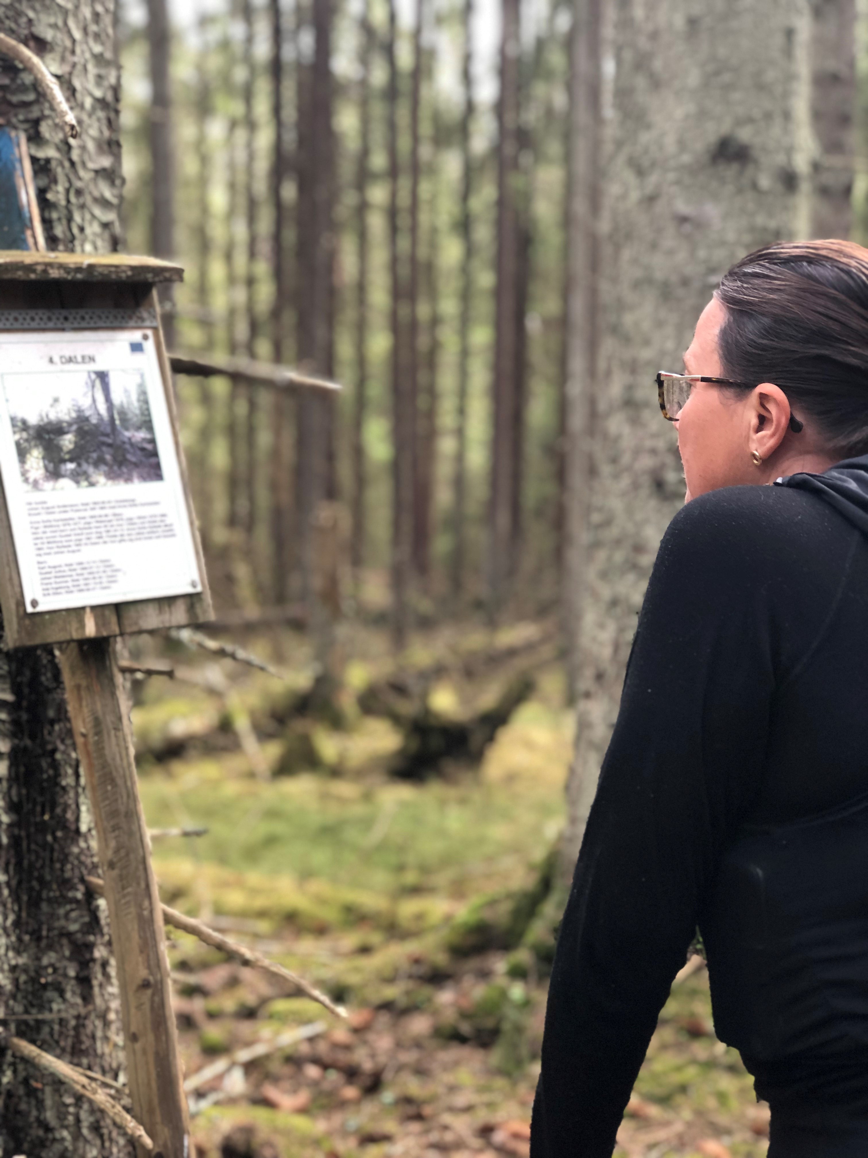 Kvinna läser på skylt i vandringsled 