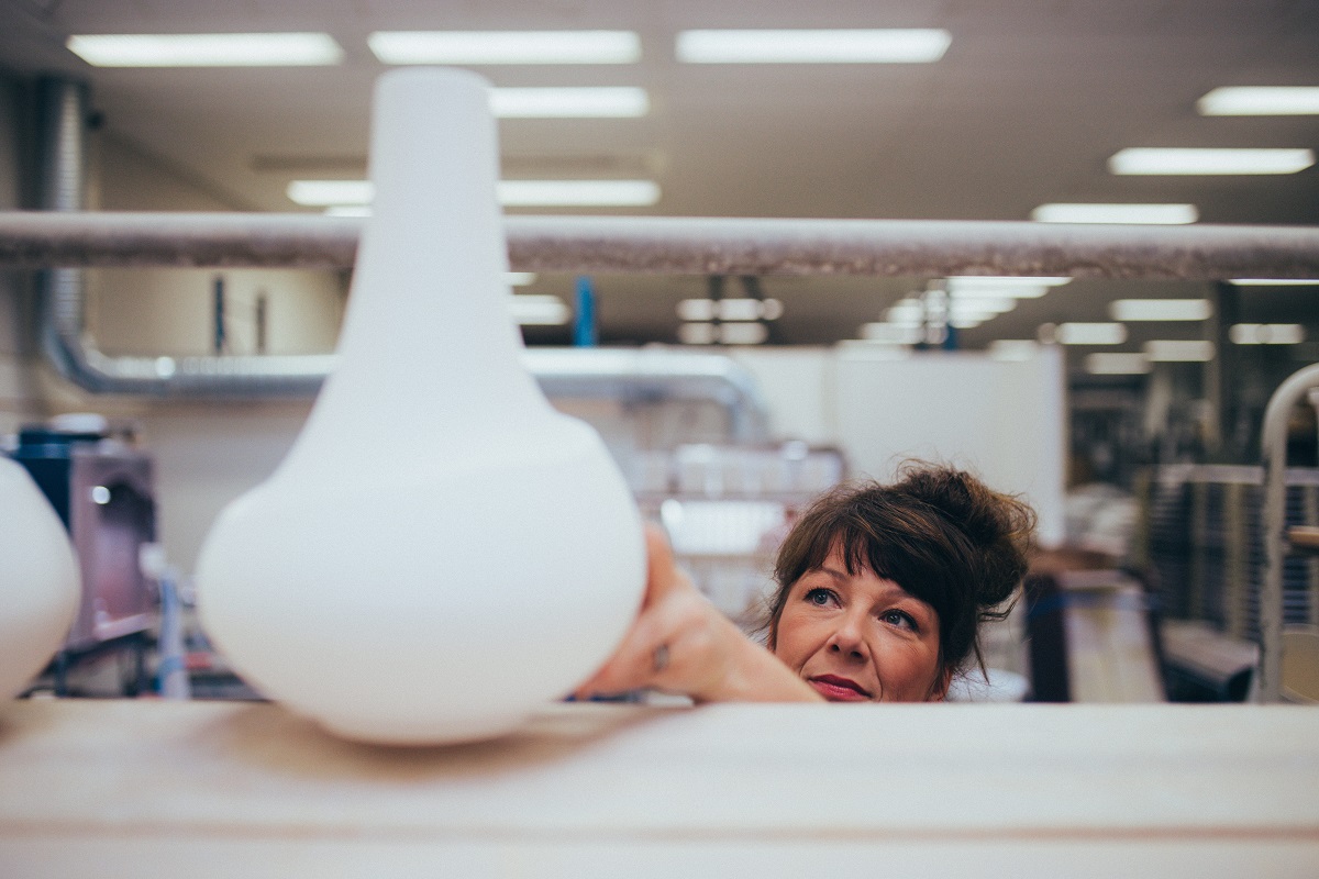 En kruka som ställs upp på en hylla i en keramisk verkstad