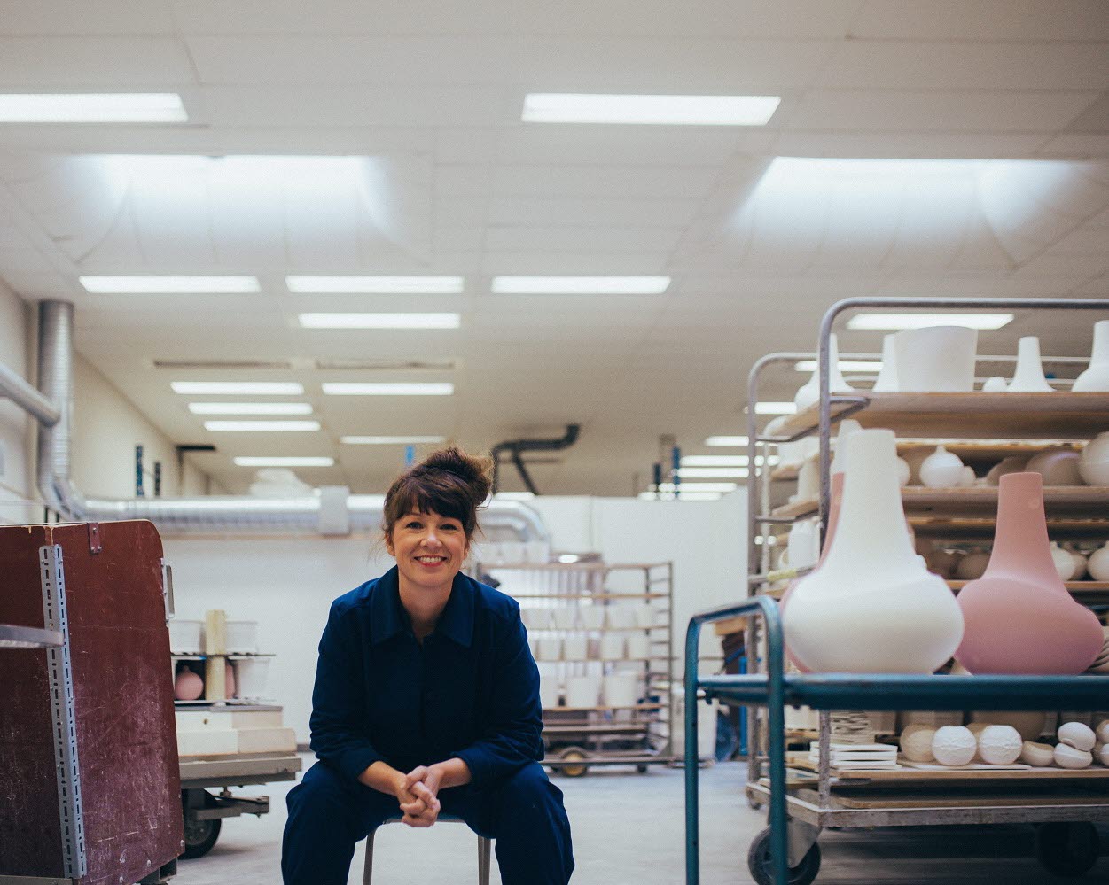 En kvinna sitter på en stol i en keramisk verkstad