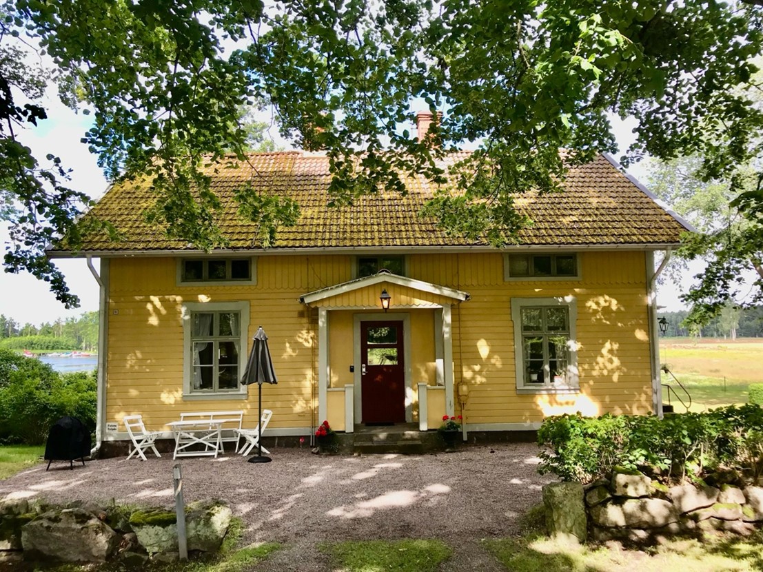 An older house with a sitting group in front.