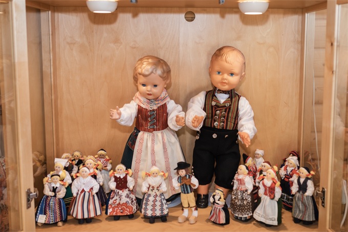 Flertal dockor klädda i den svenska folkdräkten. Två störres dockor och 19 små dockor. 