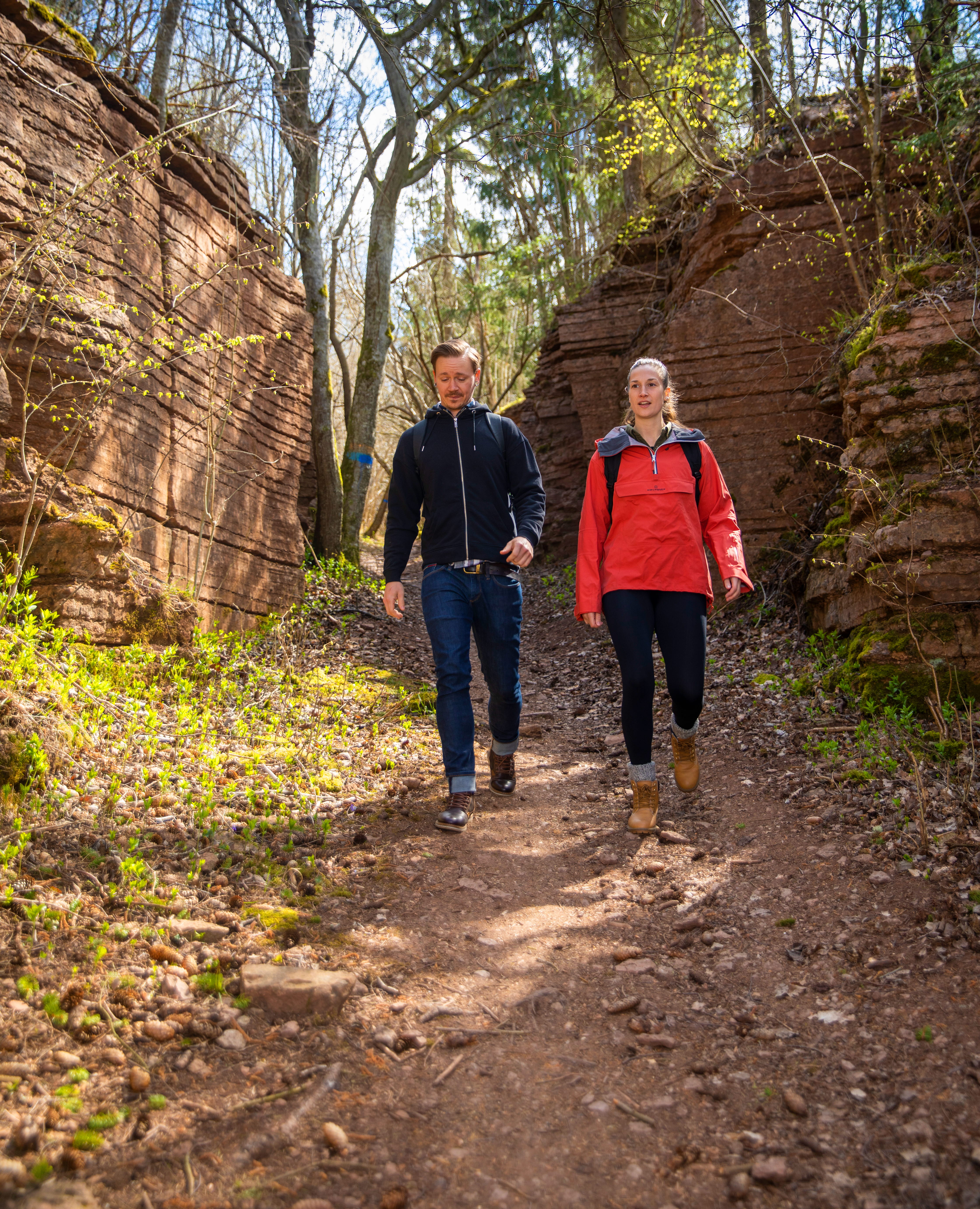 En man och en kvinna vandrar, stigen är omgiven av klippor på båda sidor.