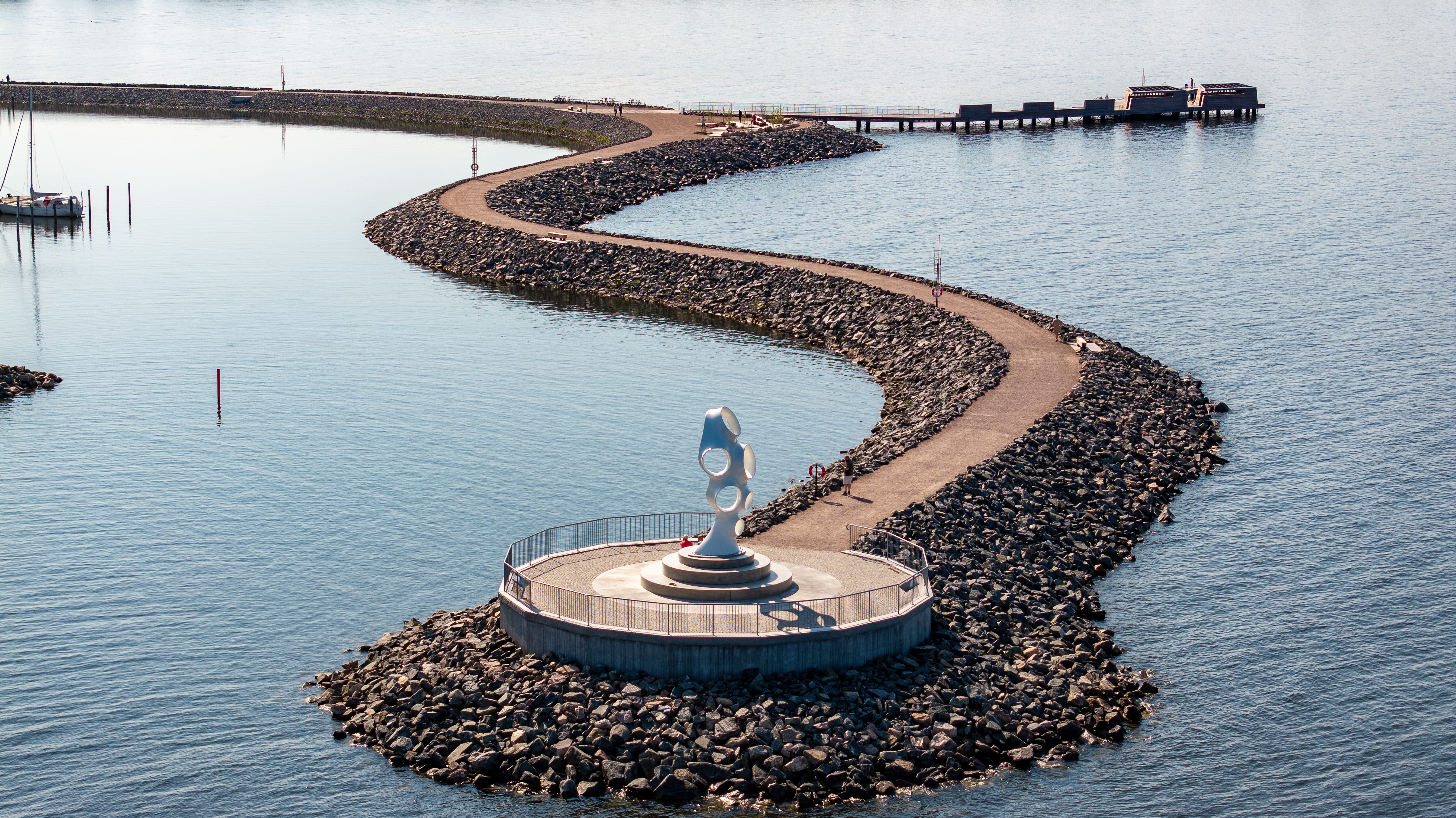 Framnäs Strandpark with the sculpture HOLD, a large contemporary artwork by the waterfront surrounded by water and walking paths.