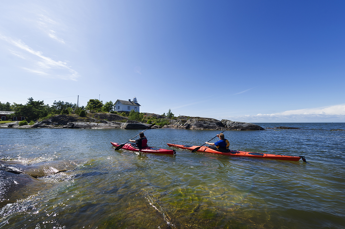 Två kajakpaddlare i skärgården en vacker och solig sommardag.