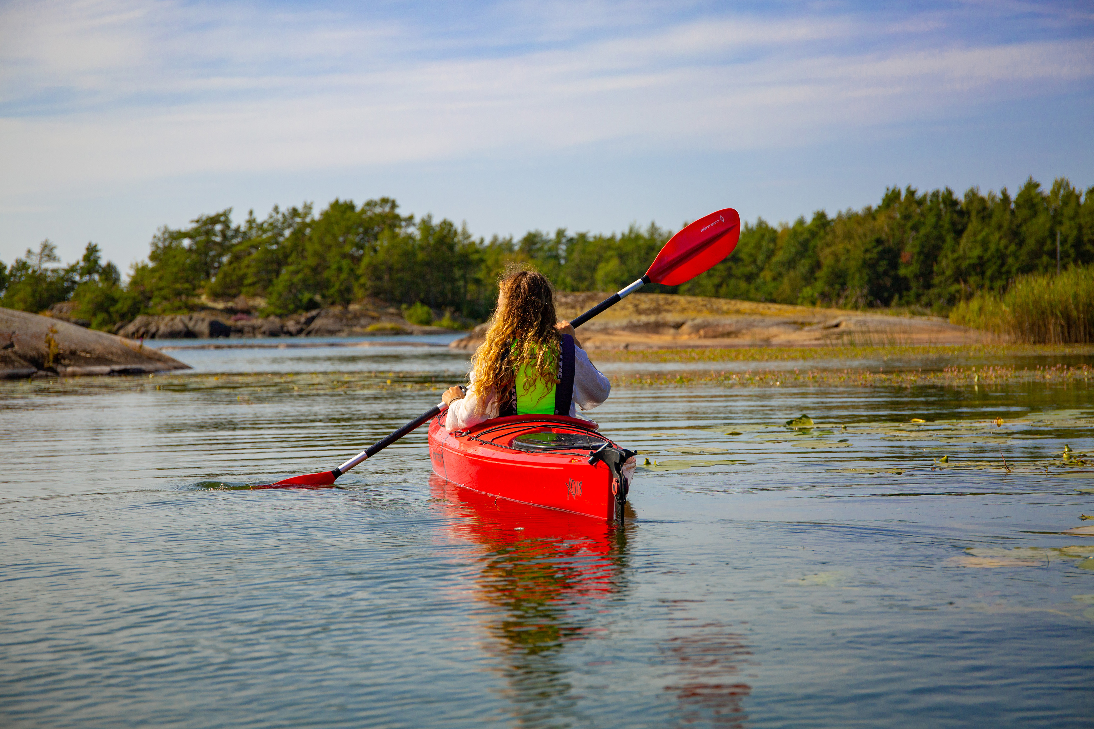 A person sitting in a red kayak in a lake