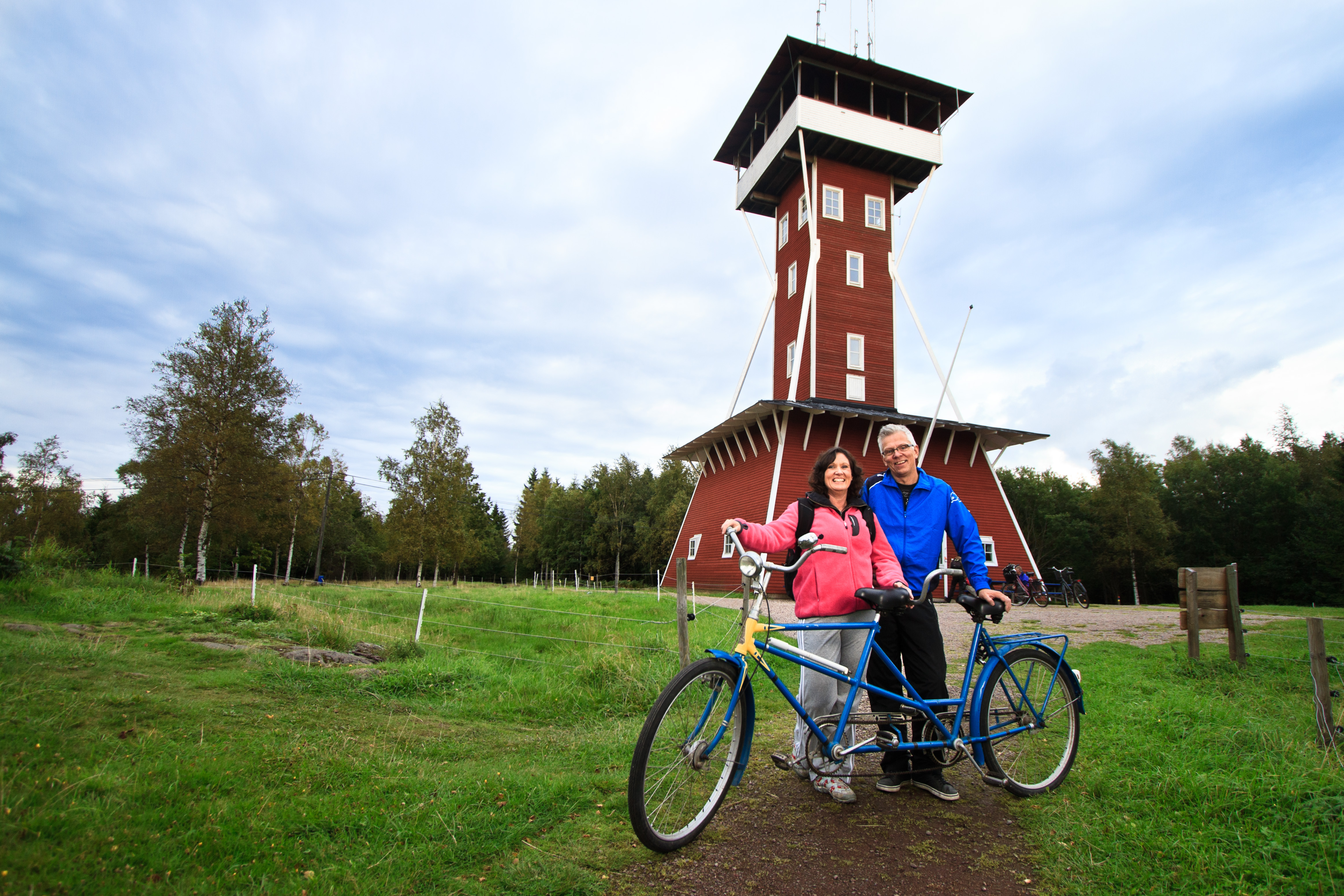 Två cyklar framför ett högt rött torn.