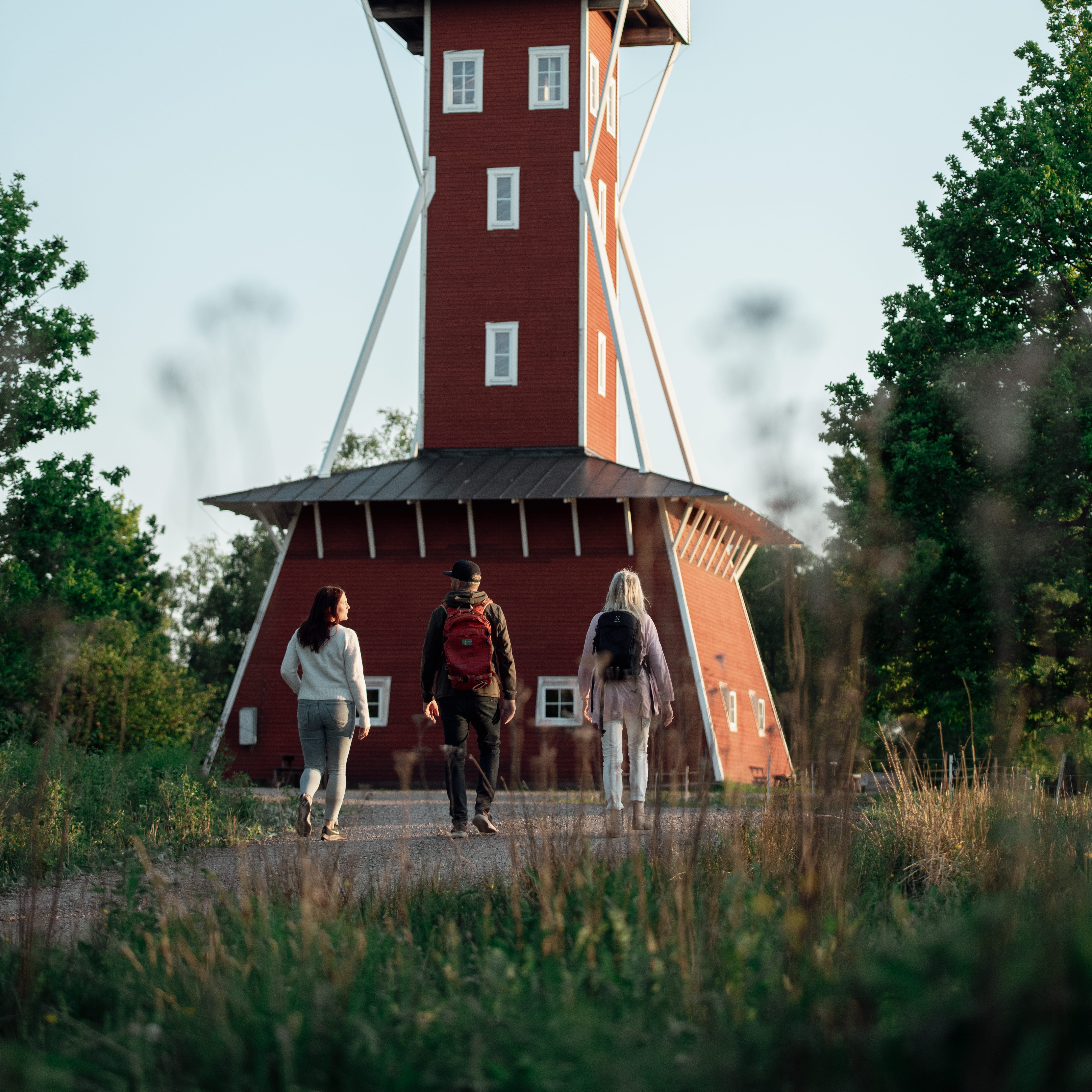 Tre personer vandrar mot Kinnekulle utsiktstorn
