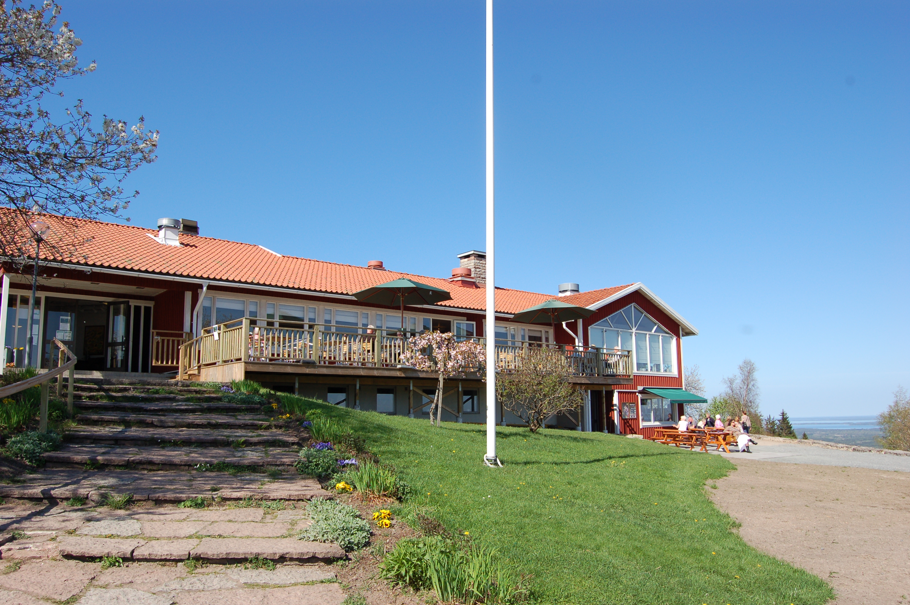 En röd restaurangen på toppen av den blomstrande berget Kinnekulle.