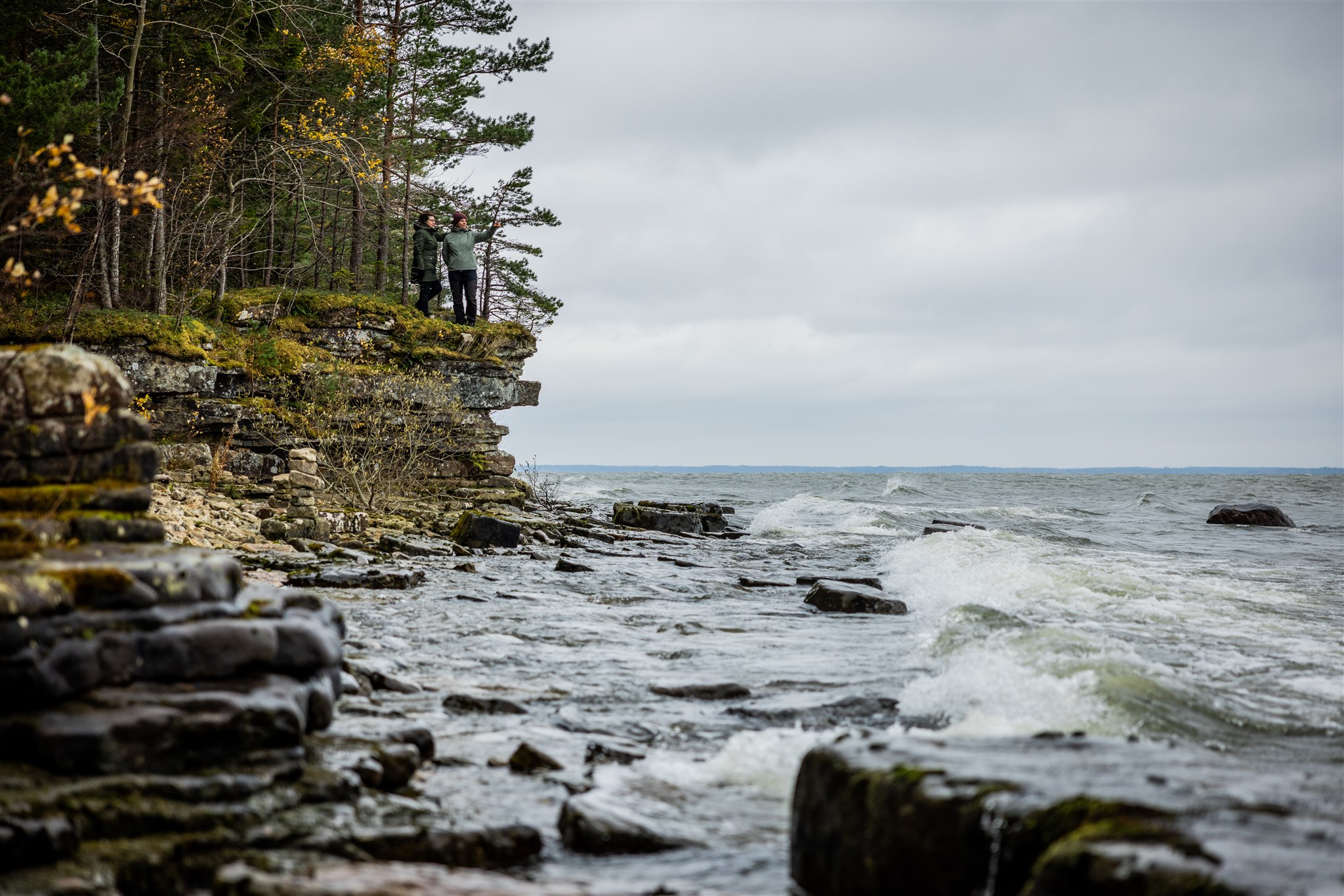 Två kvinnor blickar ut över Vänern vid Söcke grottor, Kinnekulle