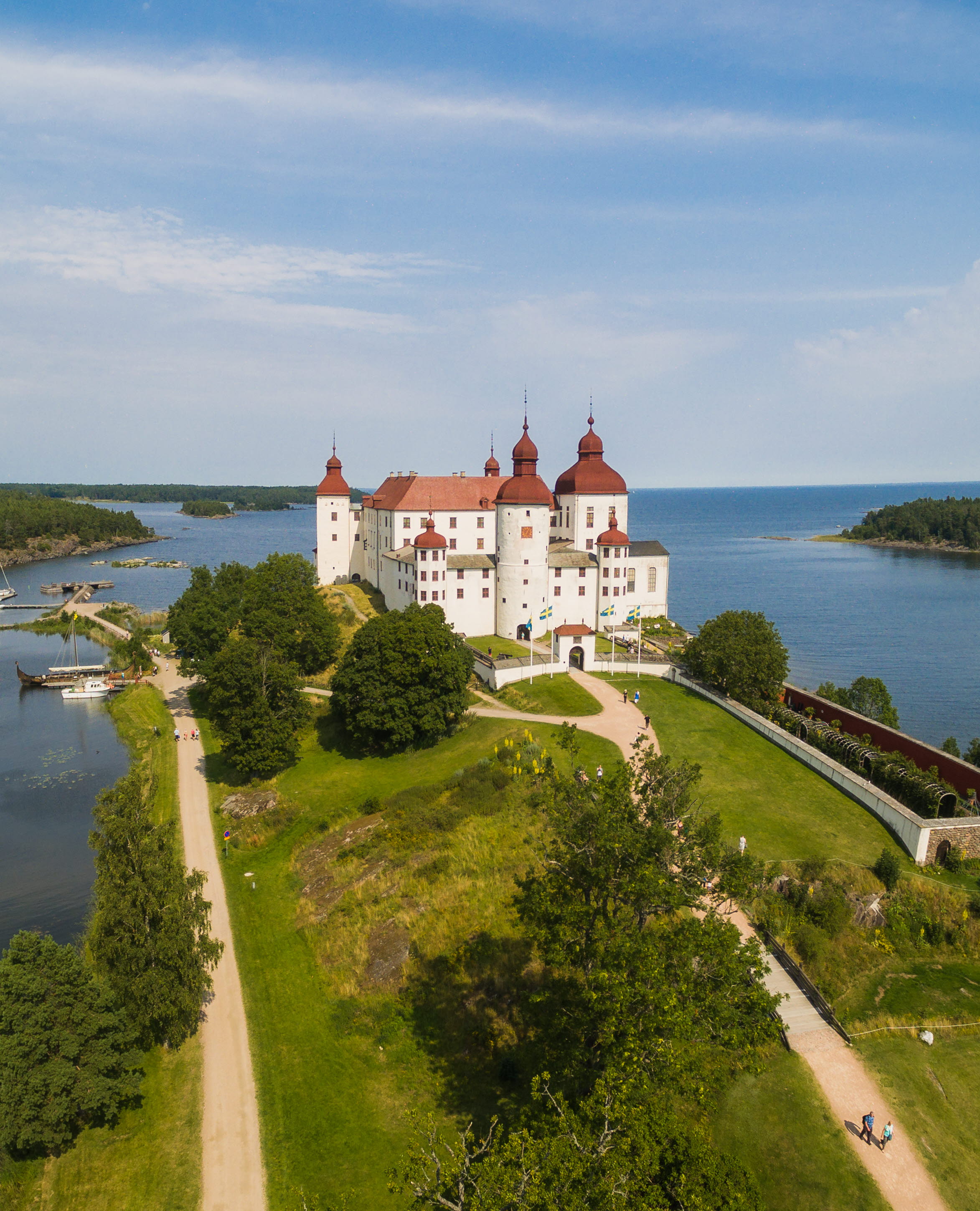 Flygbild på ett vitt slott med rött tak. 