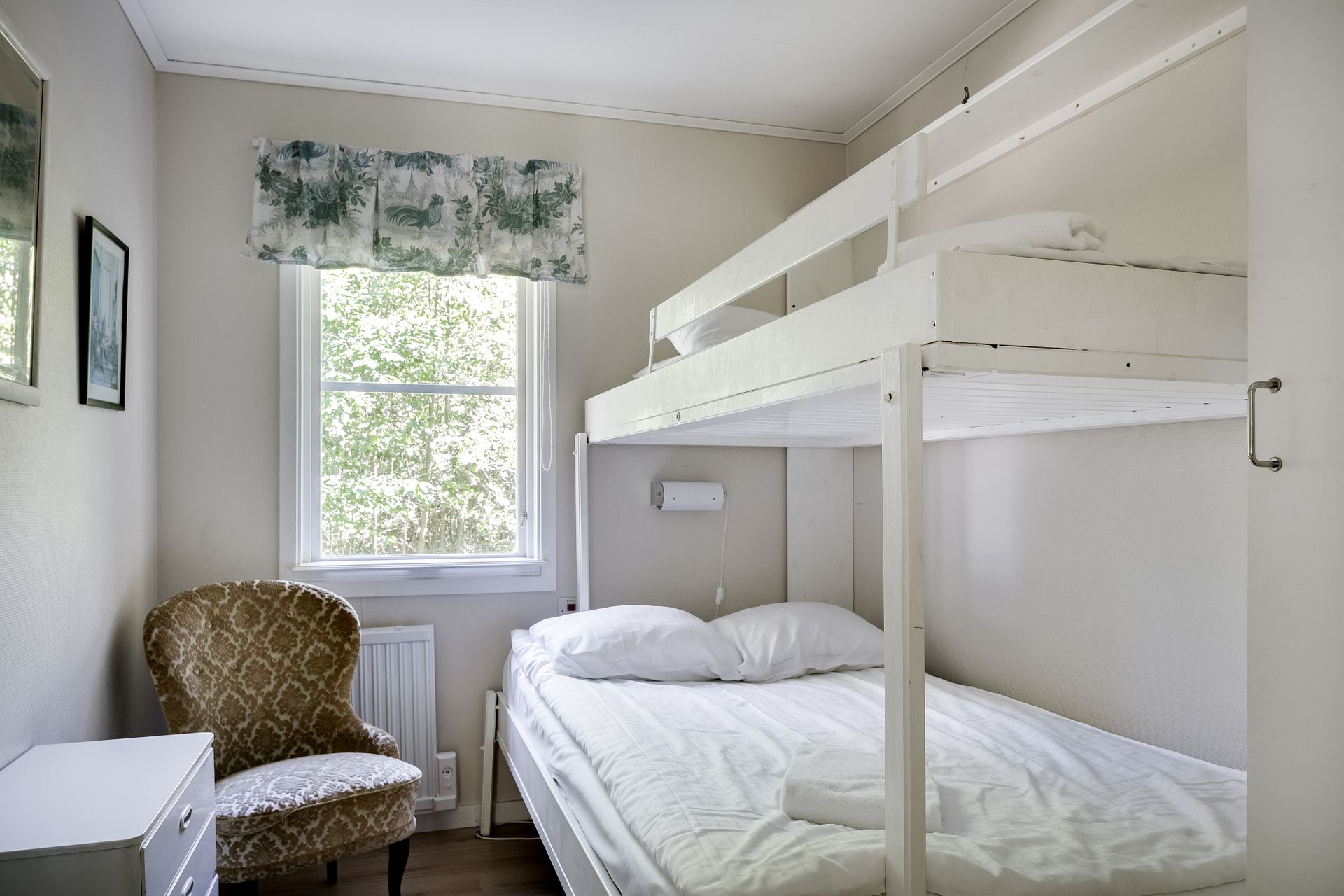 Ett rum med en vit vångssäng